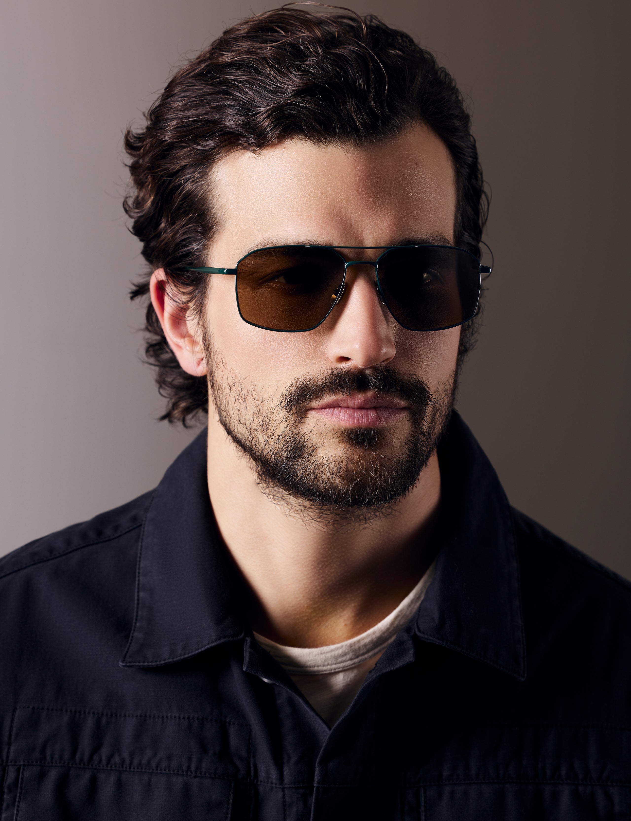 Front view of man wearing Arches Sunglass in Green with Brown Lens from AETHER Apparel. 