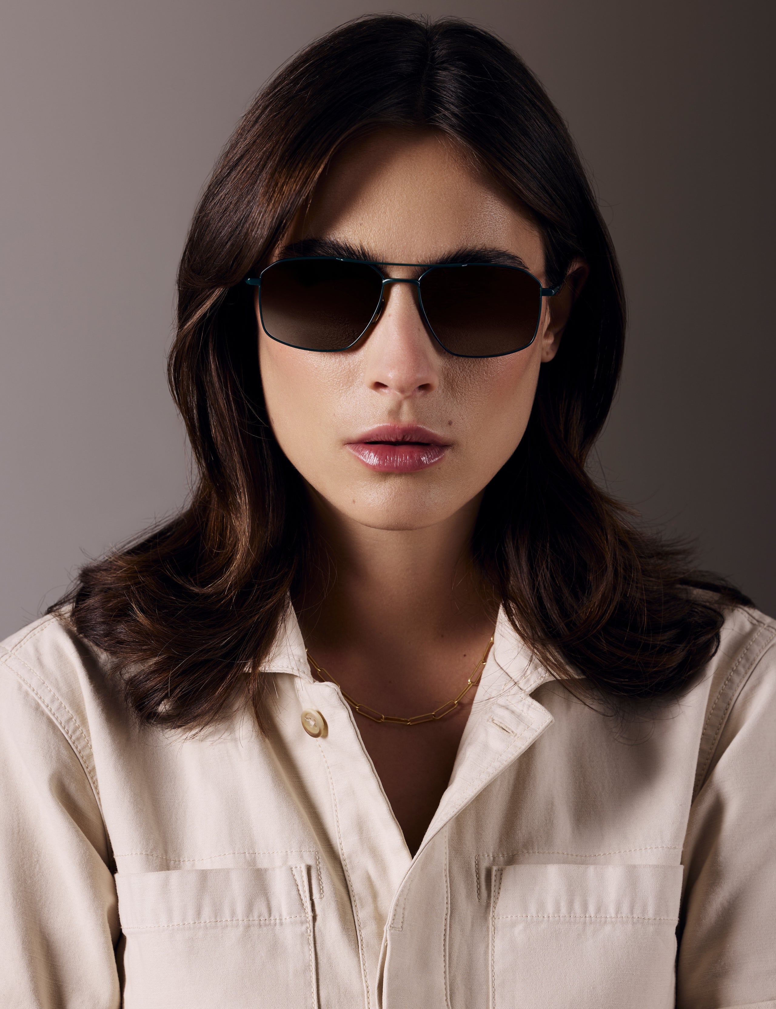 Front view of woman wearing Arches Sunglass in Green with Brown Lens from AETHER Apparel. 