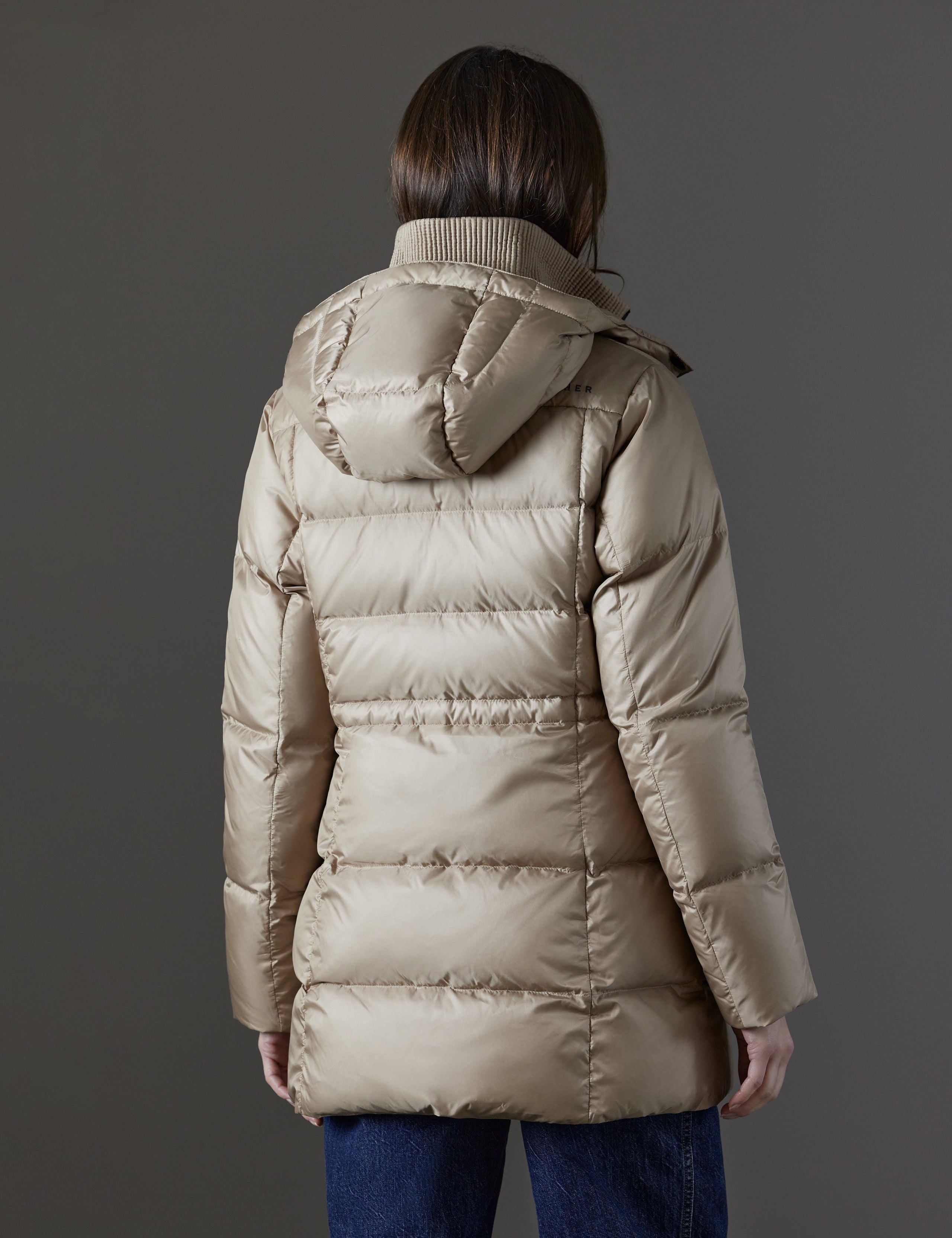 Rear angled view of woman wearing Aura Puffer Long in Chinchilla Brown from AETHER Apparel.