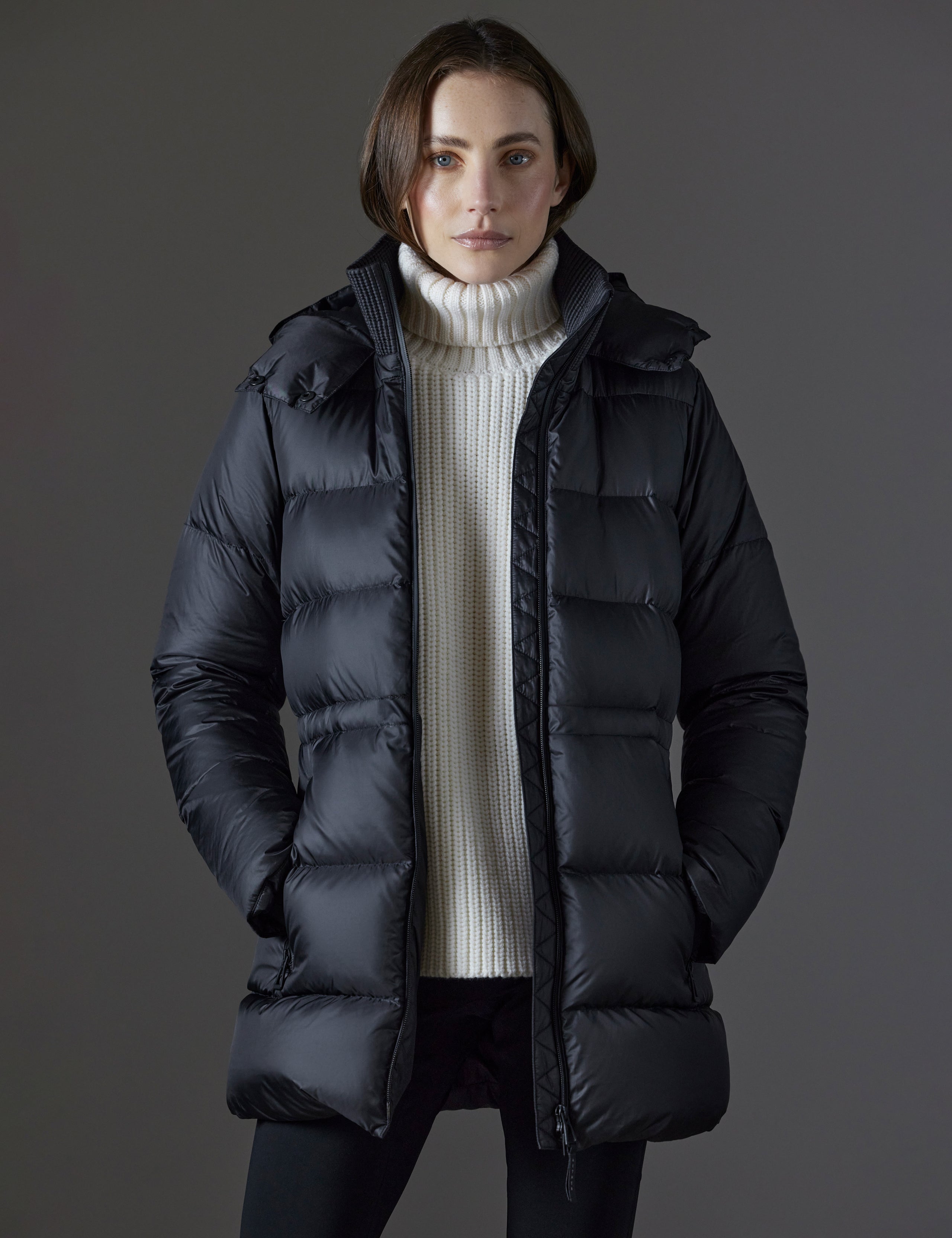 Front body view of woman wearing Aura Puffer Long in Onyx Black from AETHER Apparel.