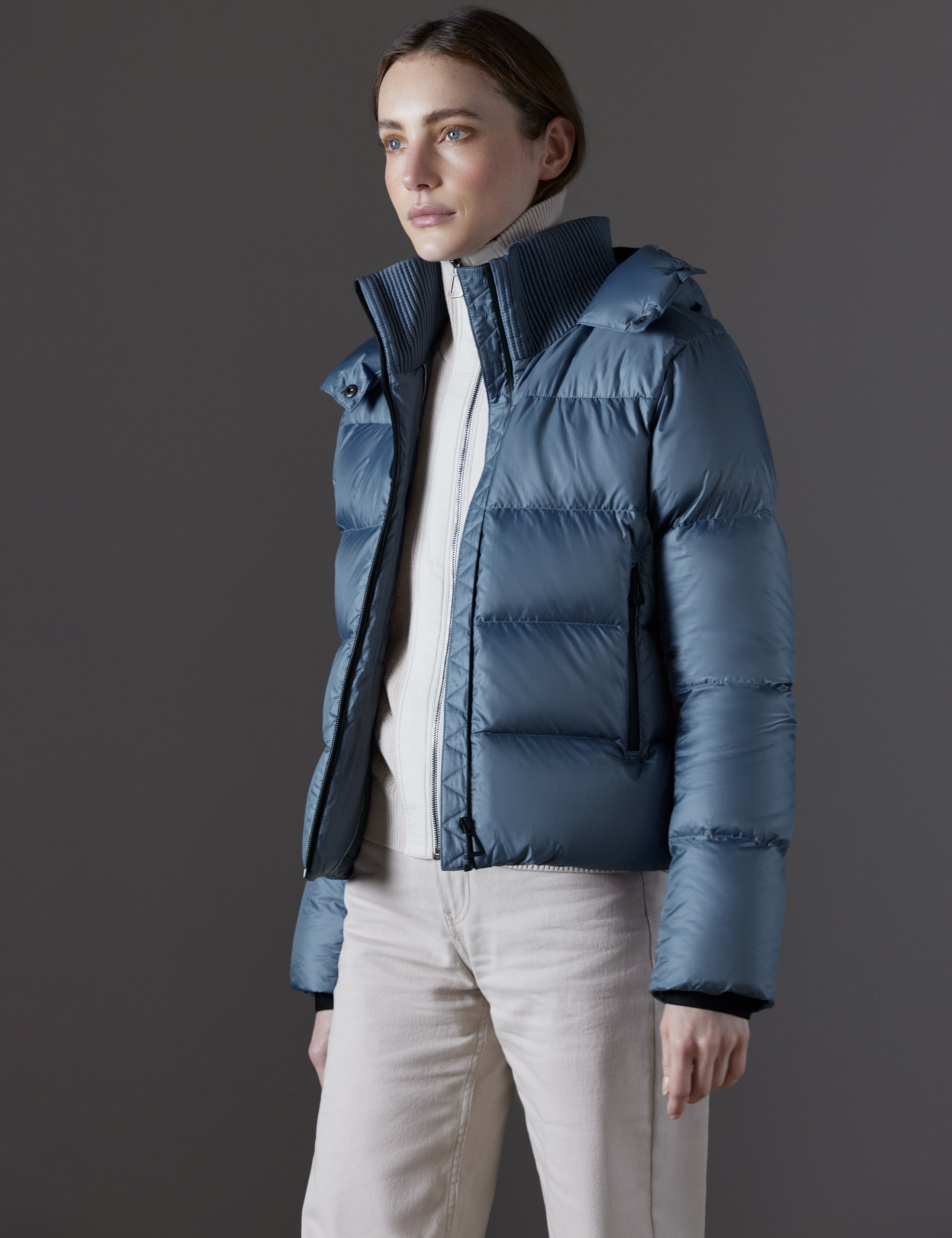 Front angled view of woman wearing Aura Puffer Jacket in Portal Blue from AETHER Apparel.