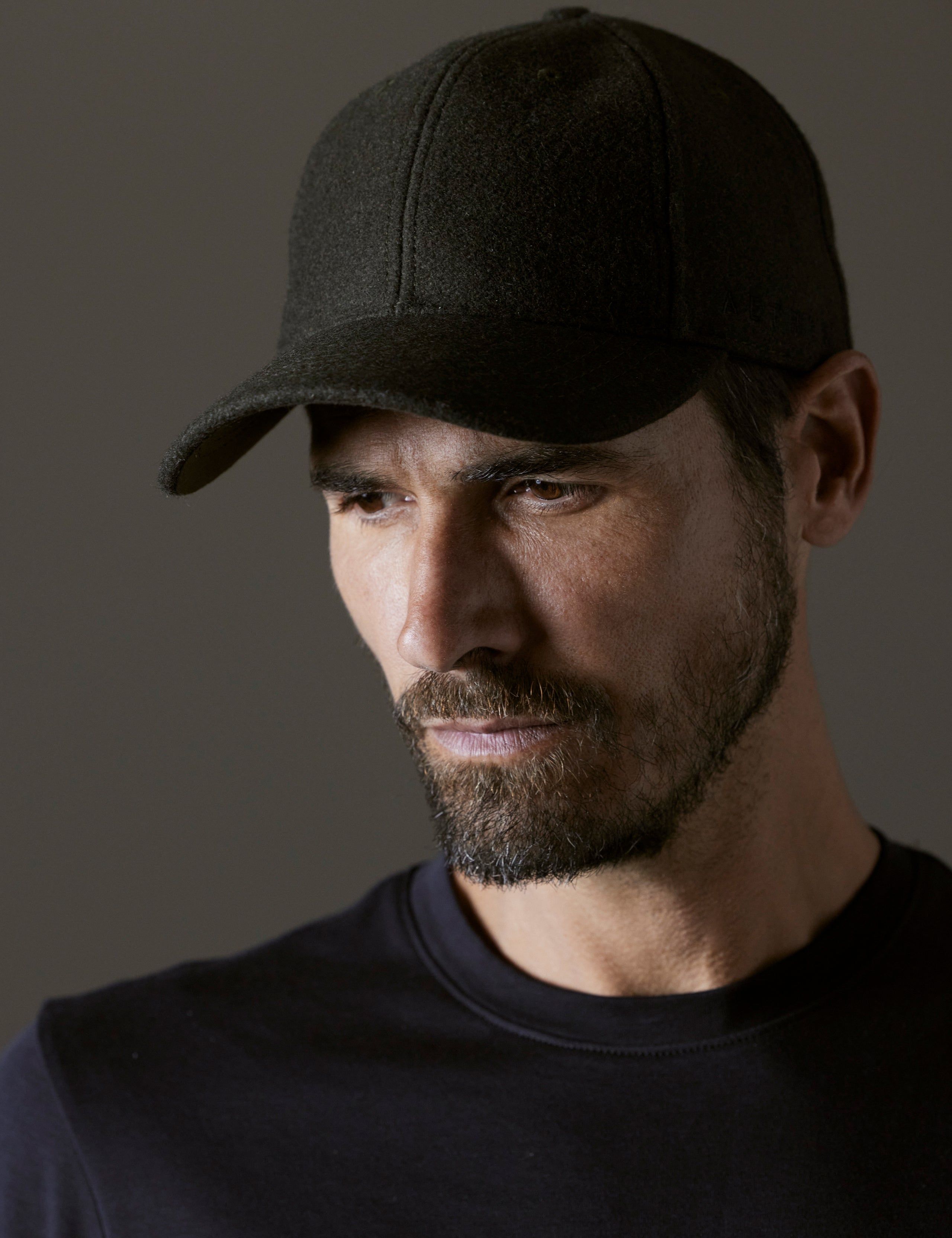 Front angled view of man wearing AETHER Wool Hat in Dark Command Green from AETHER Apparel.