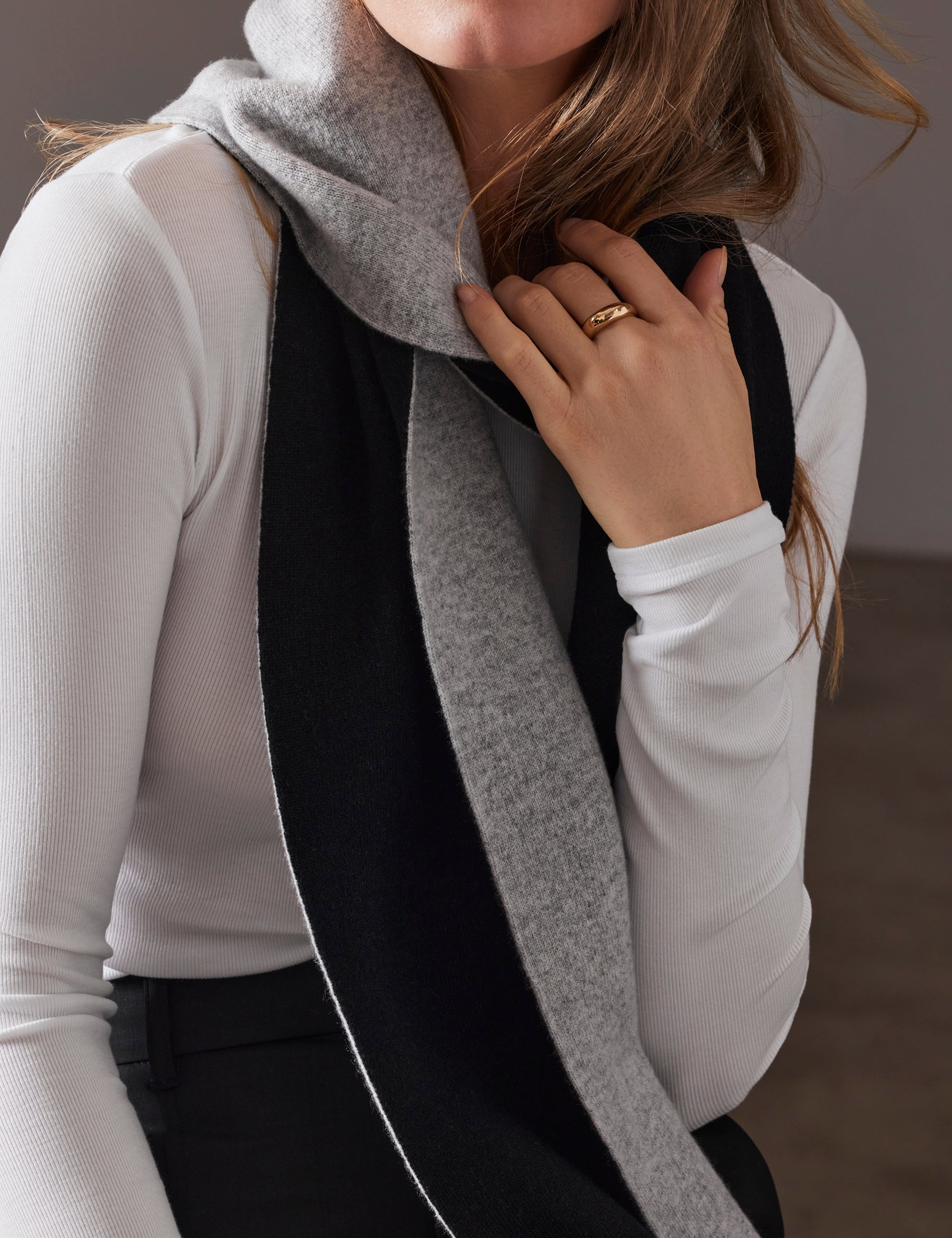 Closeup view of woman wearing Avesta Cashmere Scarf in Light Heather Grey from AETHER Apparel.