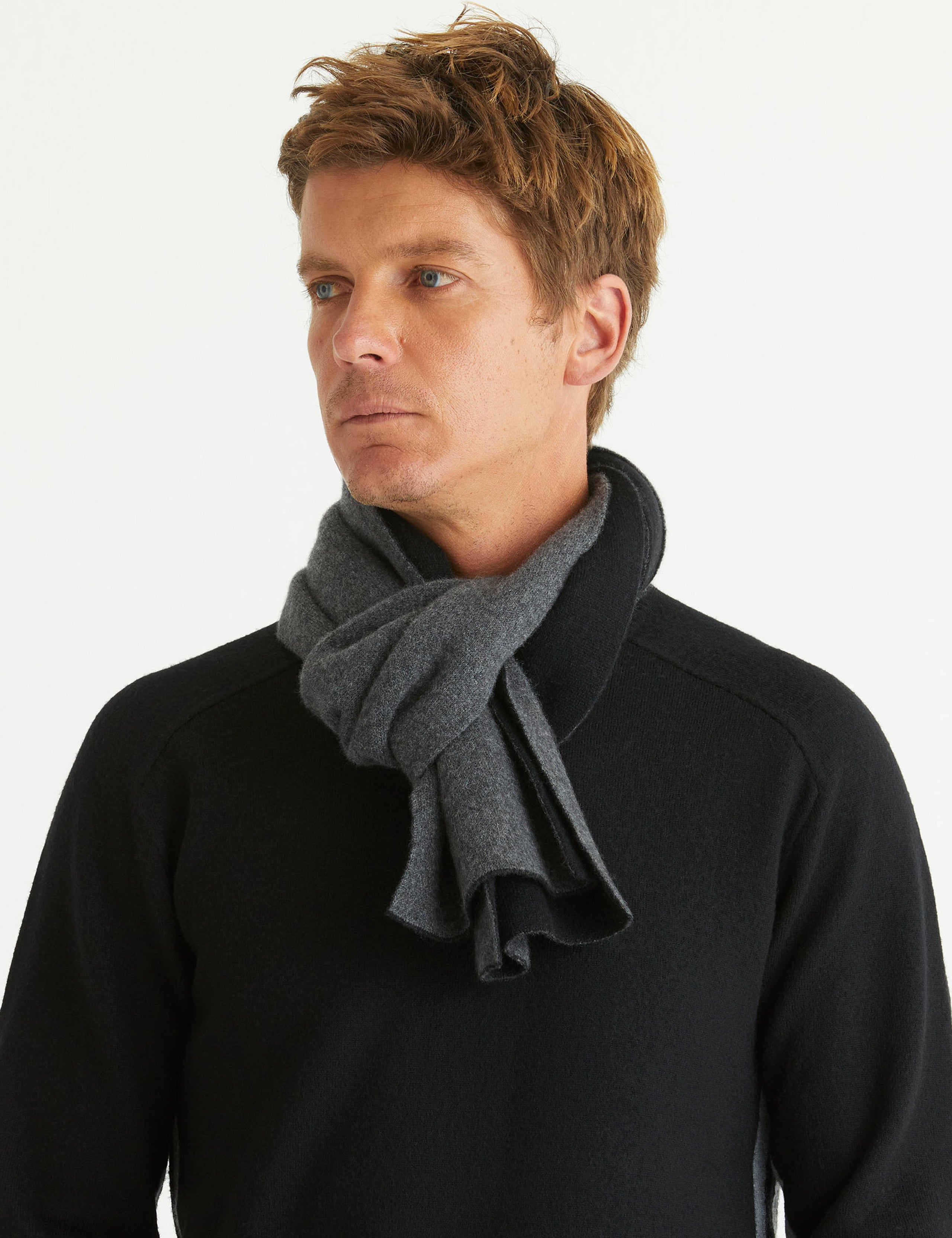 Front view of man wearing Avesta Cashmere Scarf in Onyx Black from AETHER Apparel.