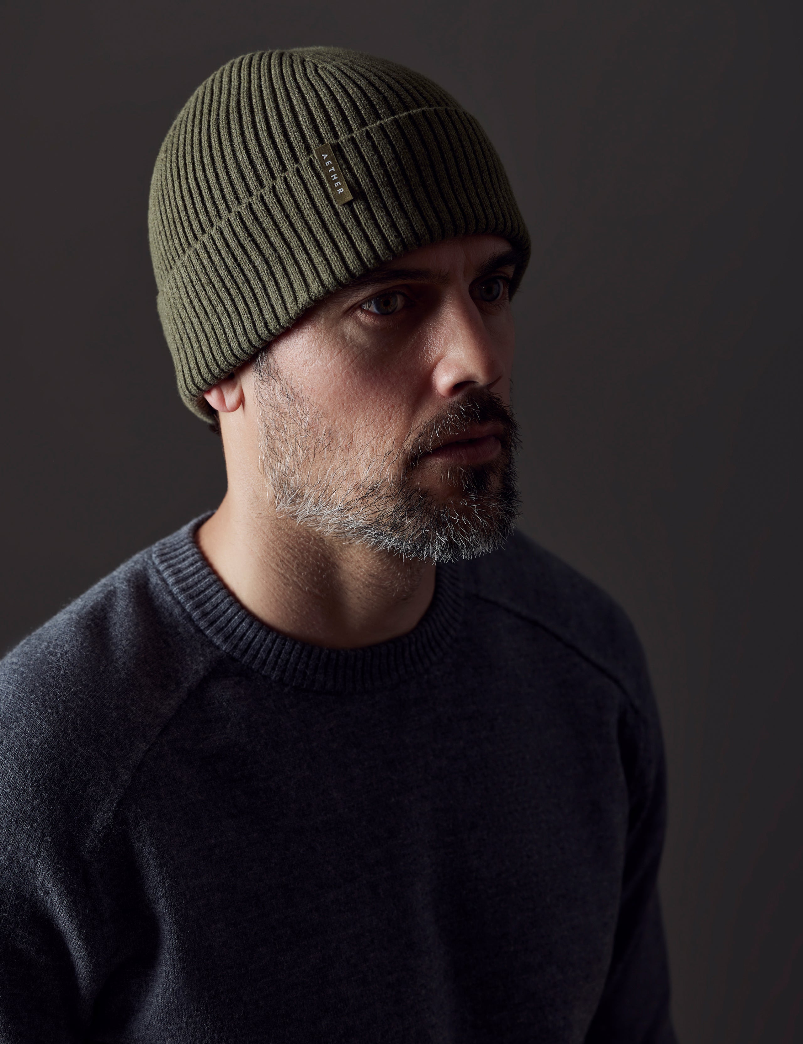 Front angled view of man wearing Chalet Cotton Beanie in Command Green Heather from AETHER Apparel. 