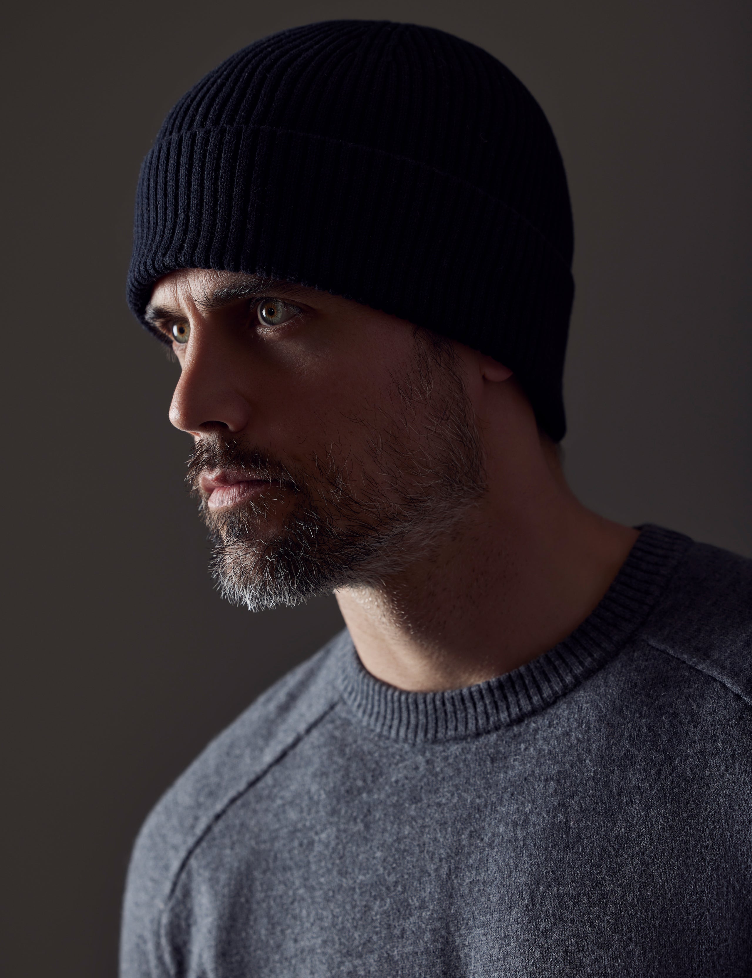 Front angled view of man wearing Chalet Cotton Beanie in Onyx Black from AETHER Apparel. 