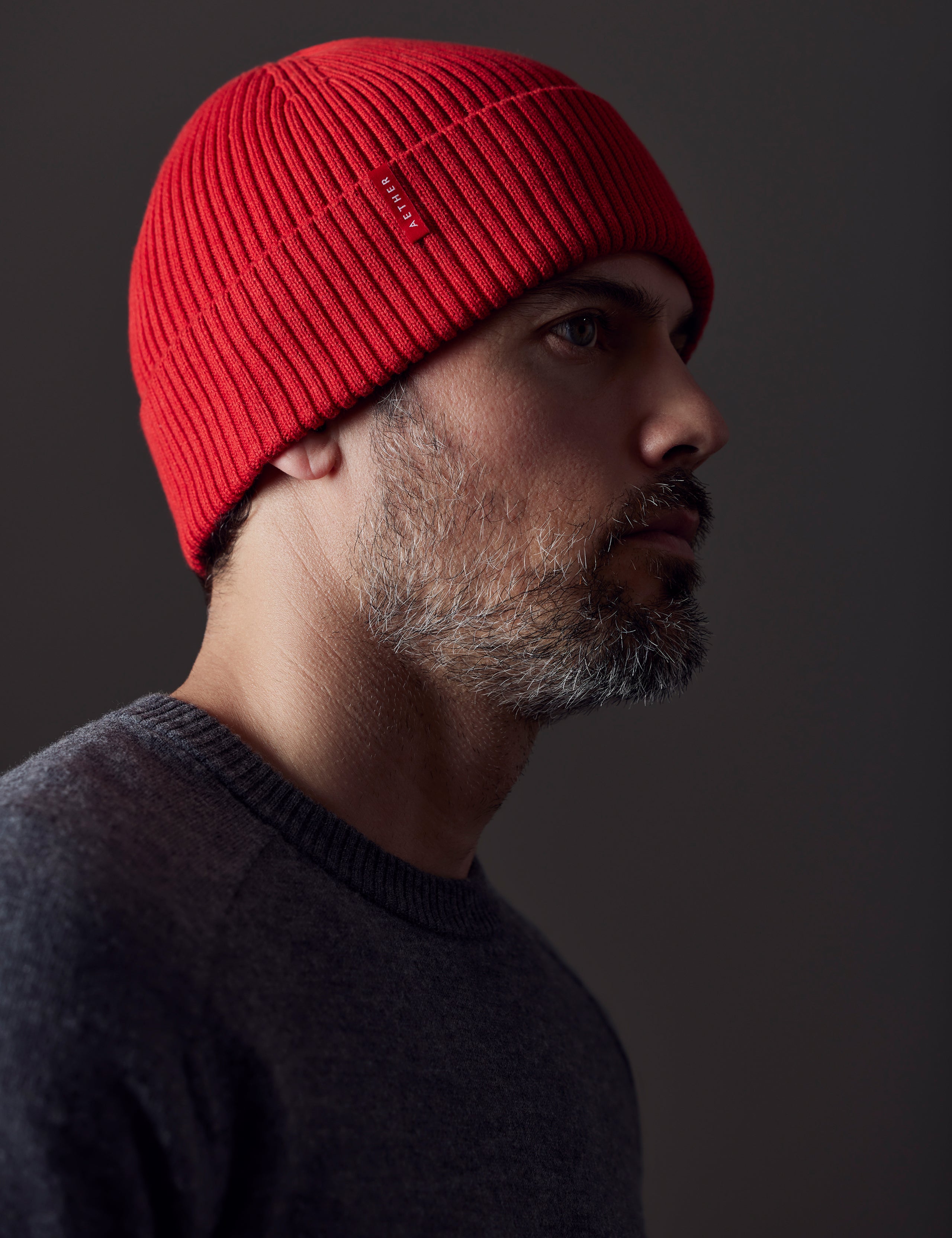 Front angled view of man wearing Chalet Cotton Beanie in Racing Red from AETHER Apparel. 