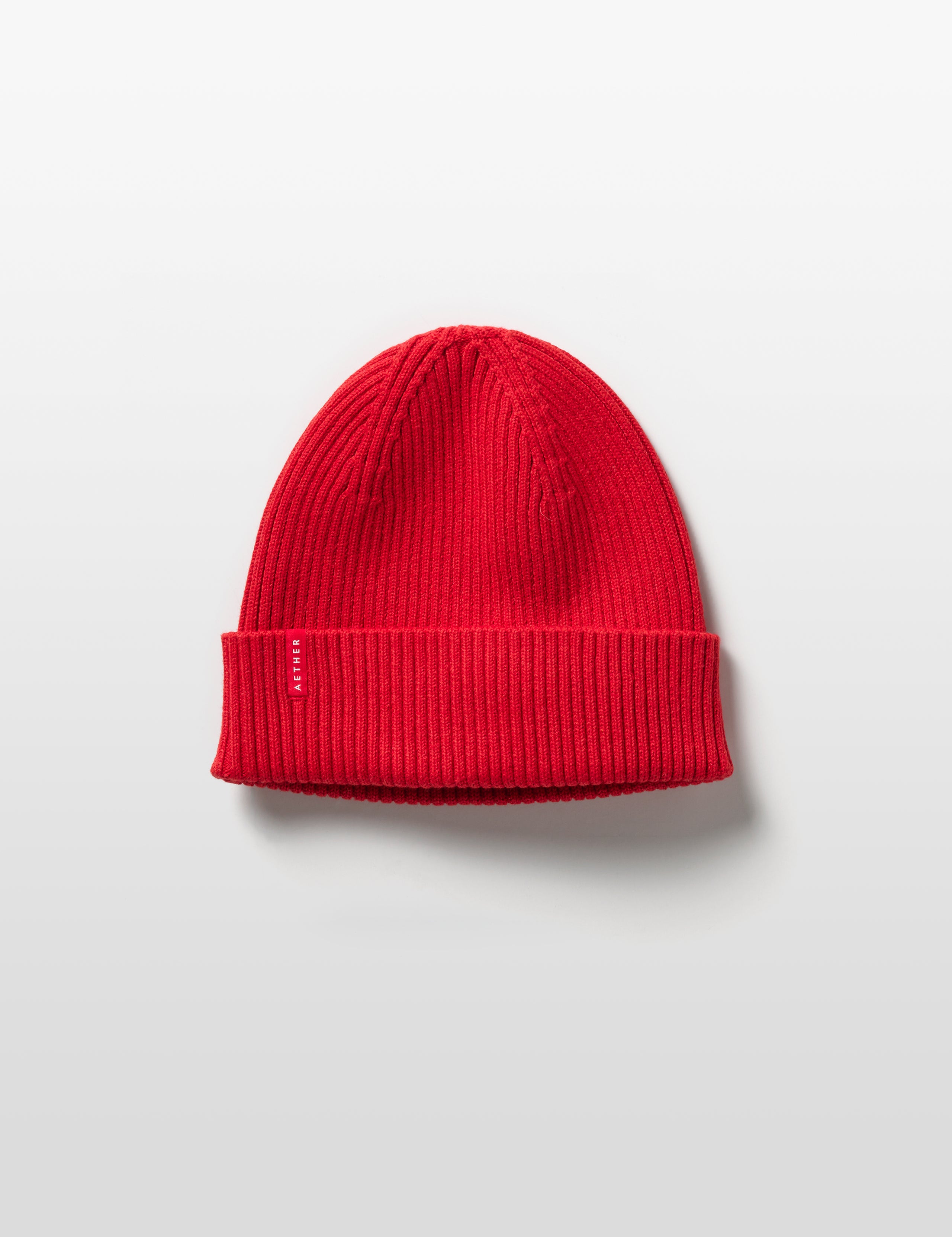 Flat lay of Chalet Cotton Beanie in Racing Red from AETHER Apparel. 