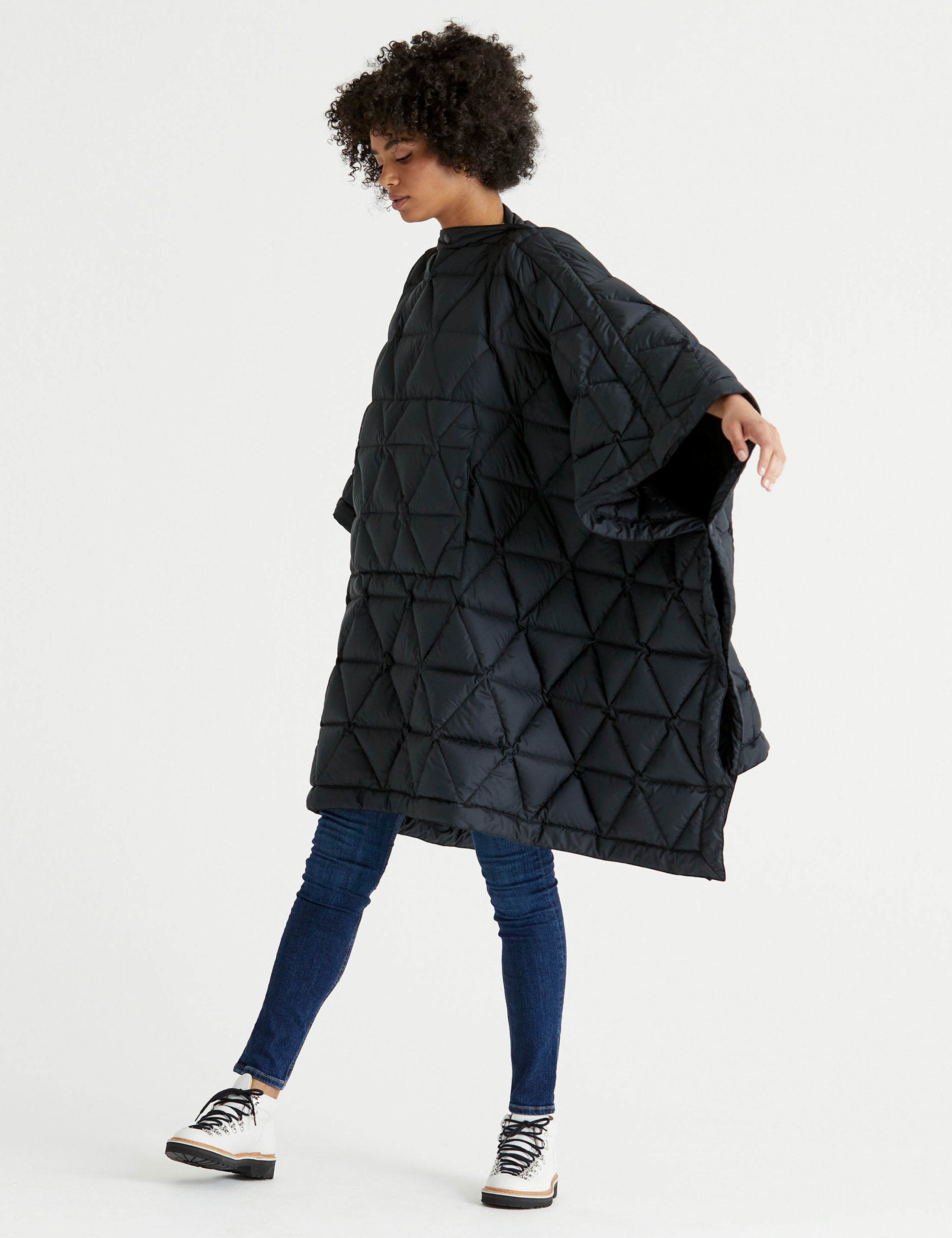Front 3/4 full-body view of woman wearing Down Poncho in Onyx Black from AETHER Apparel.