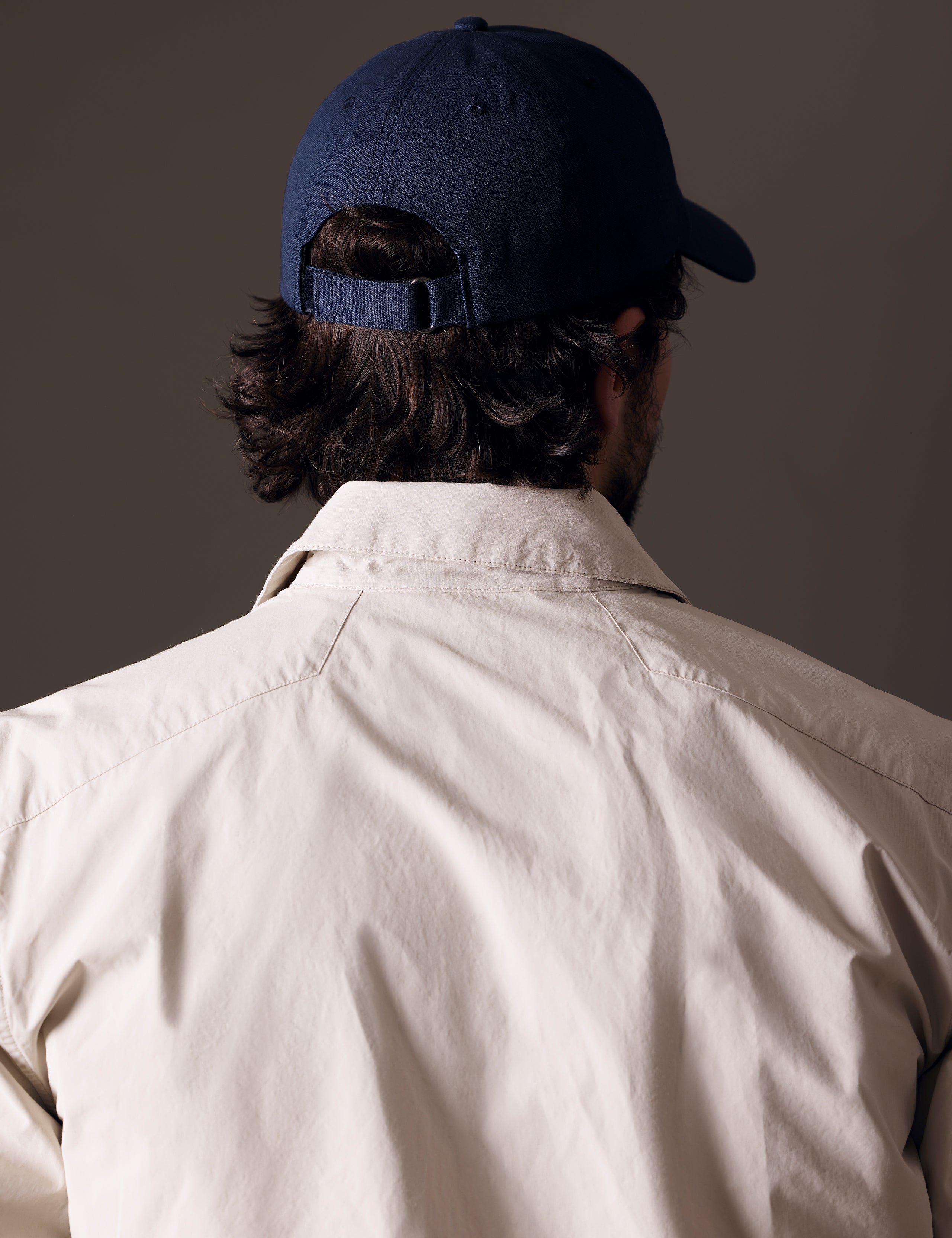 Rear angled view of man wearing AETHER Mountain Hat in Nordic Navy blue from AETHER Apparel.