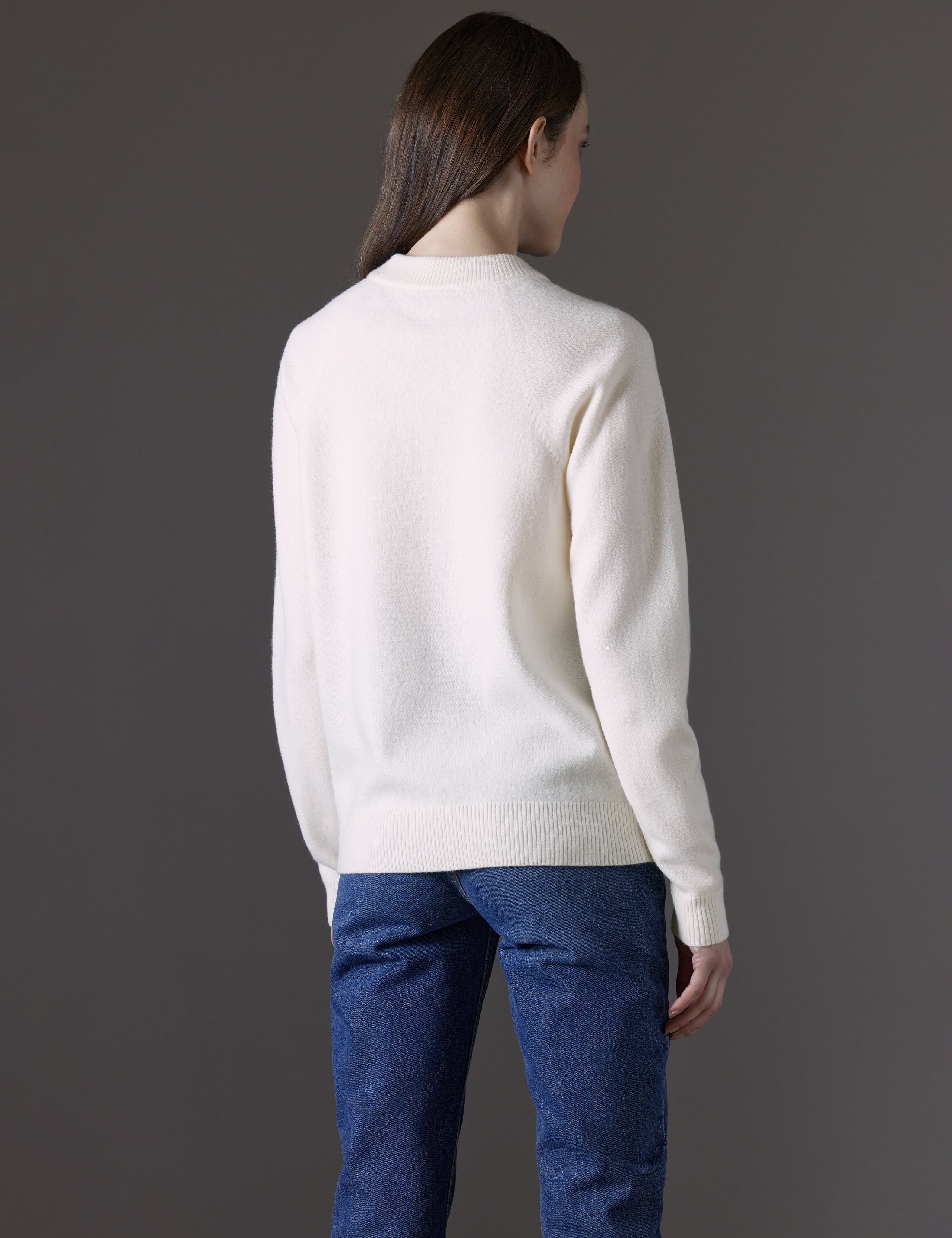 Rear angled view of woman wearing Bridget Sweater in Winter White from AETHER Apparel.