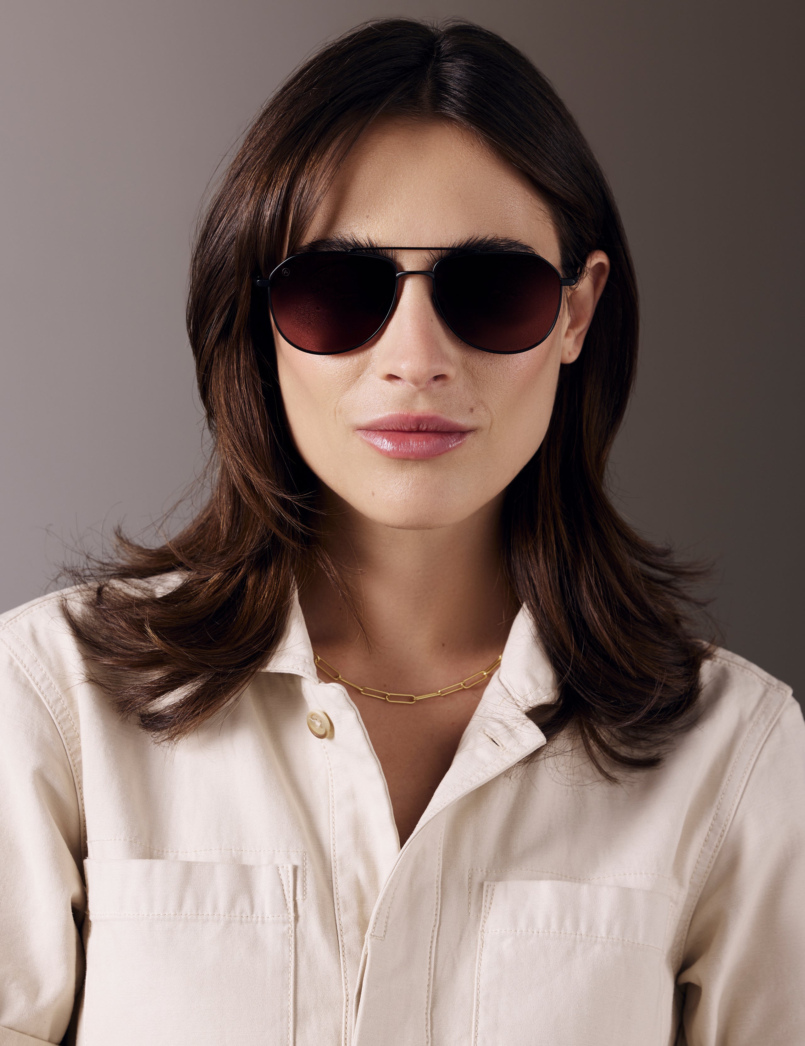 Front view of woman wearing Bryce Sunglass in black titanium with Red Lens from AETHER Apparel.