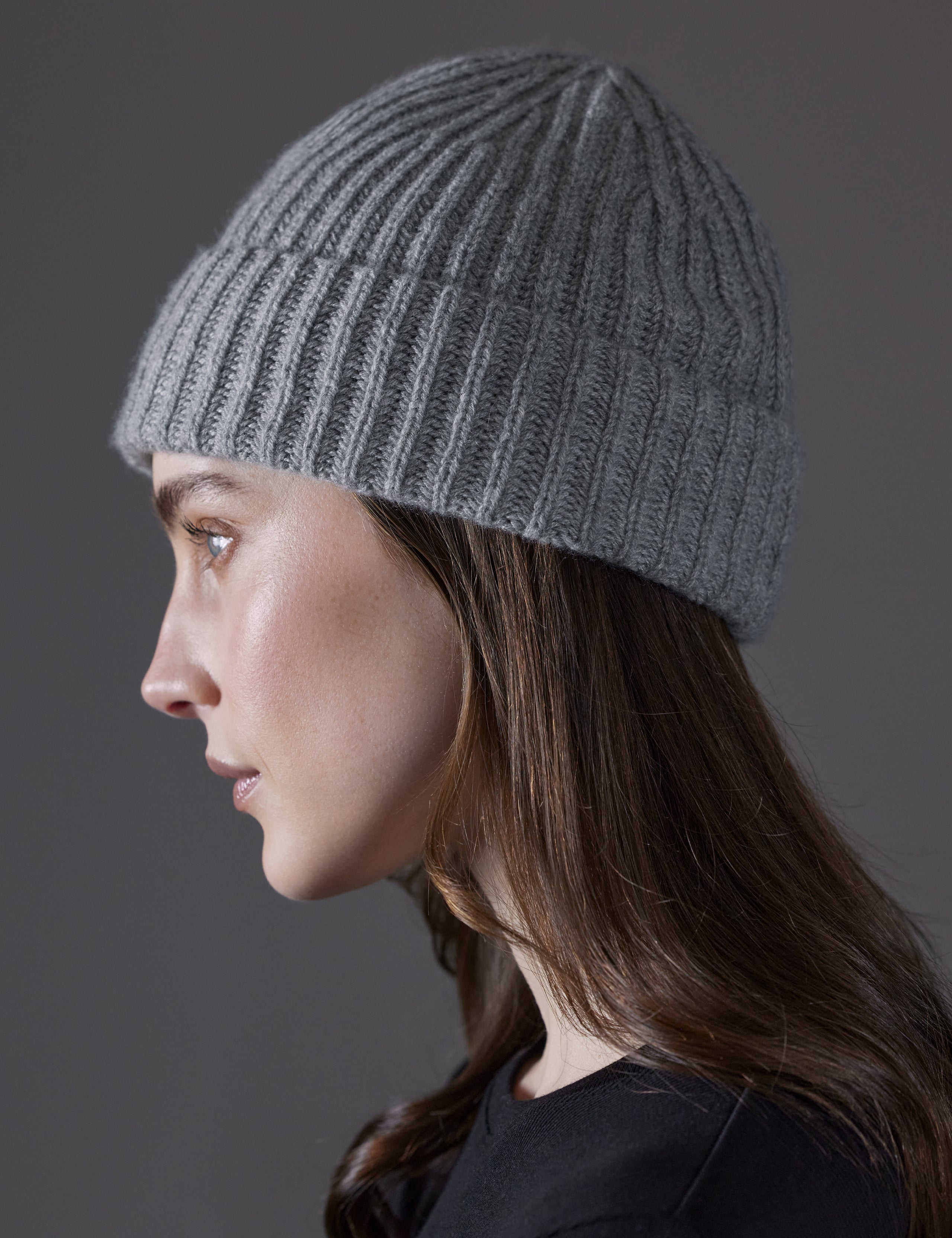 Side profile view of woman wearing Cashmere Hat in Heather Grey from AETHER Apparel. 