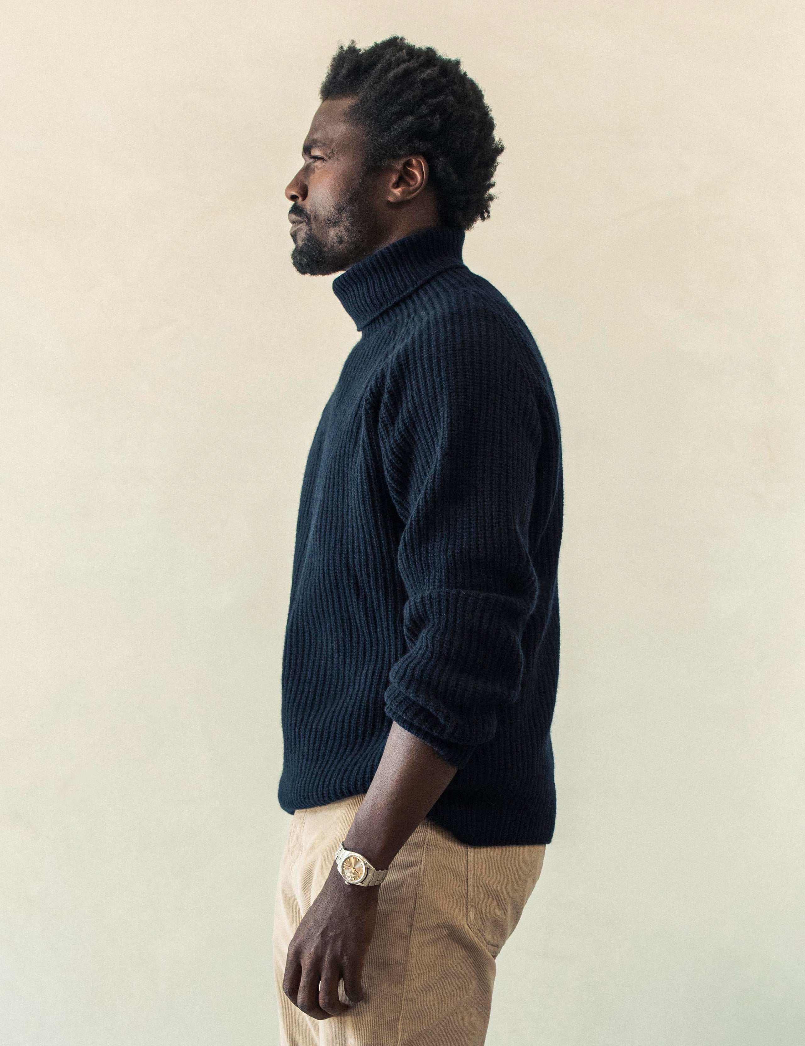 Side profile view of man wearing Finley Sweater in Total Eclipse dark blue from AETHER Apparel.