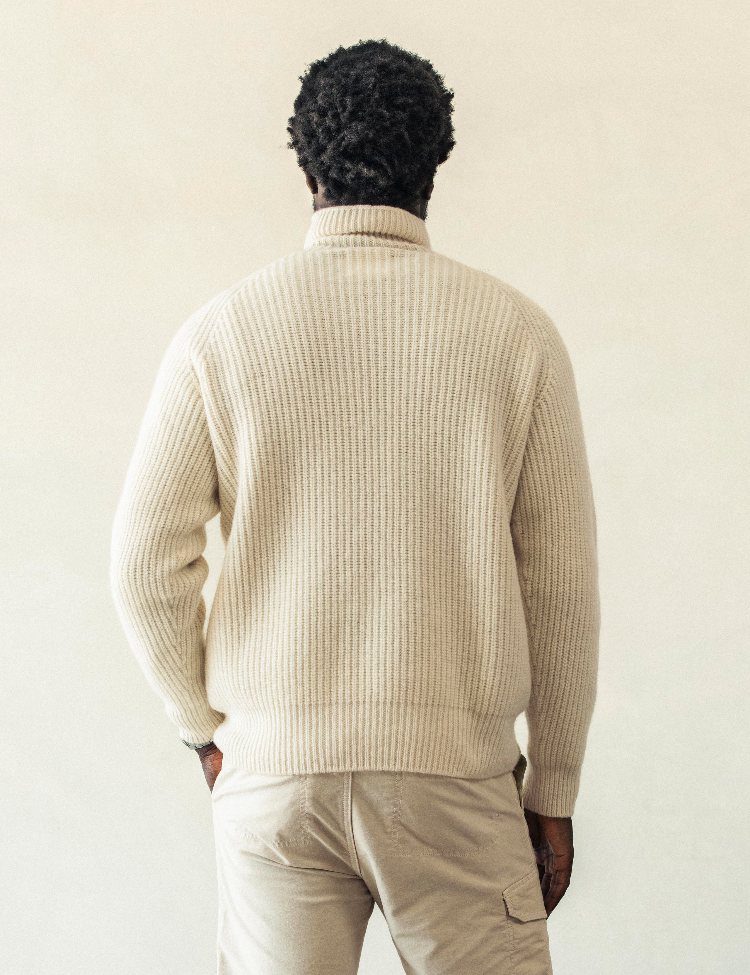 Rear view of man with hand in pant pocket wearing Finley Sweater in Winter White from AETHER Apparel.
