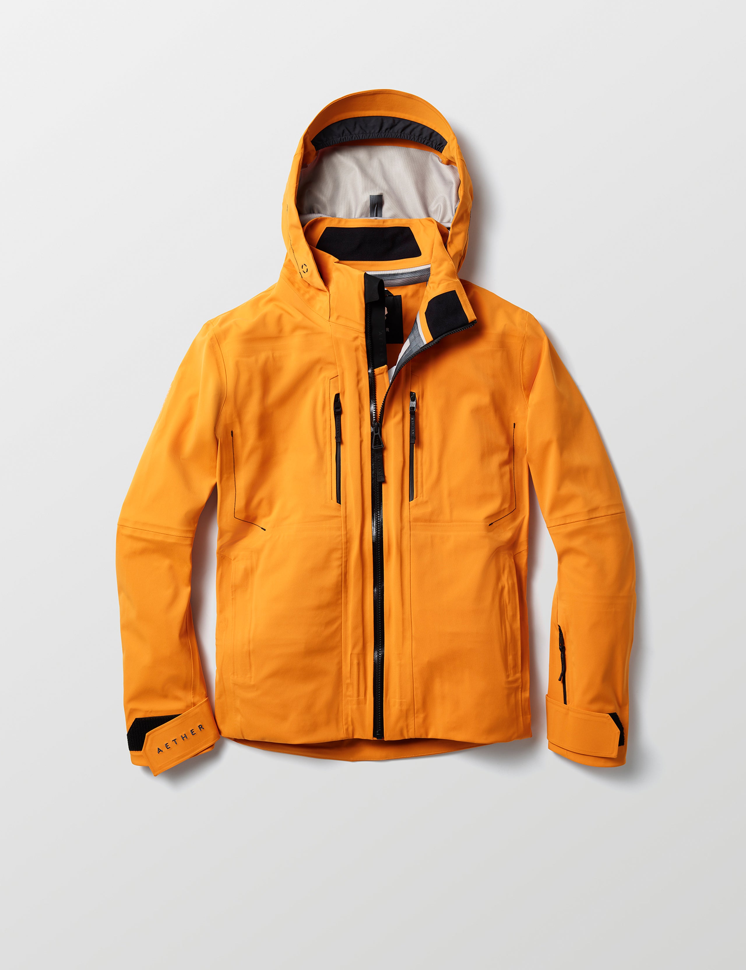 Flat lay of Altitude Snow Shell 2.0 in Autumn Orange from AETHER Apparel.