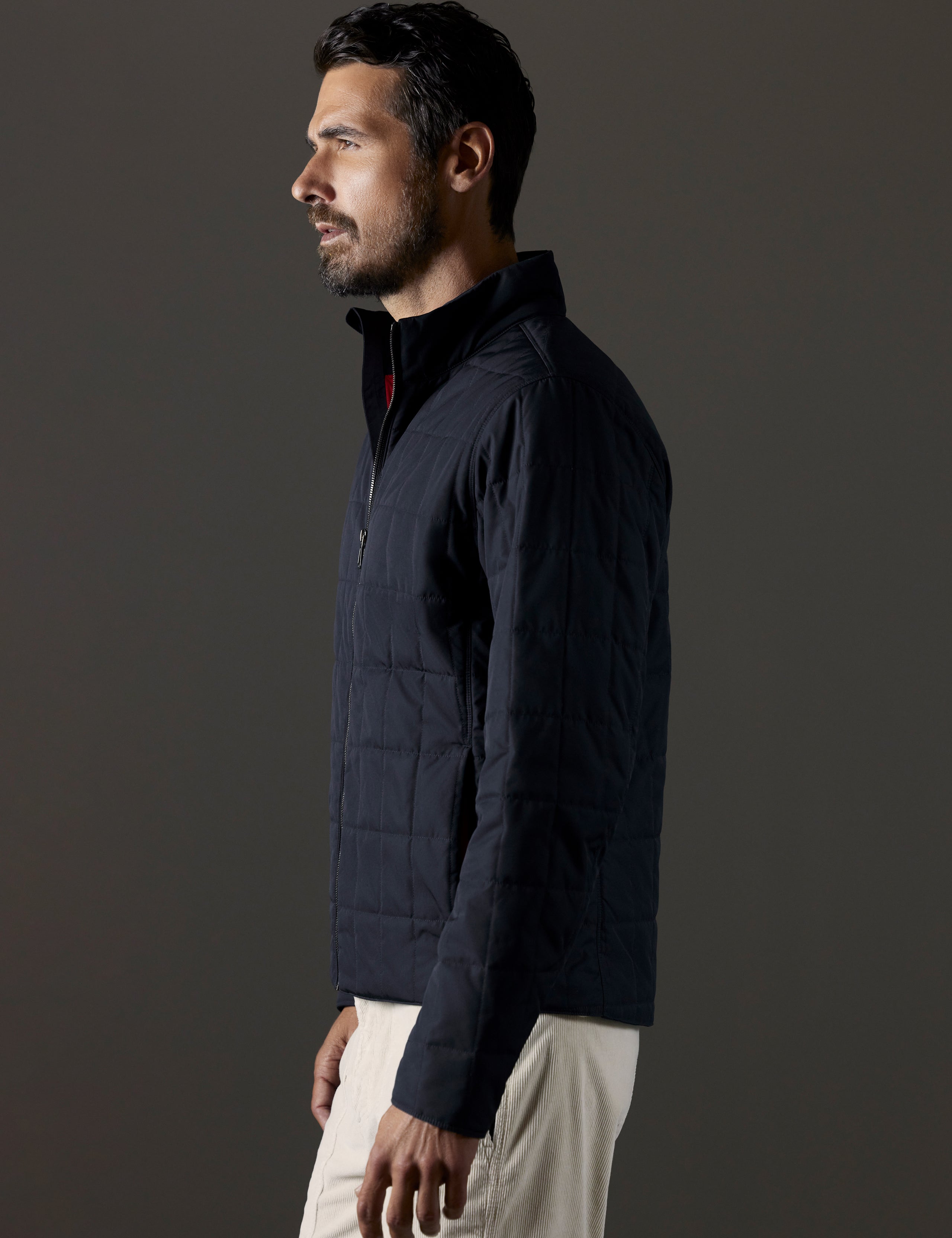 Side profile body view of man wearing Alto Jacket in Onyx Black from AETHER Apparel.