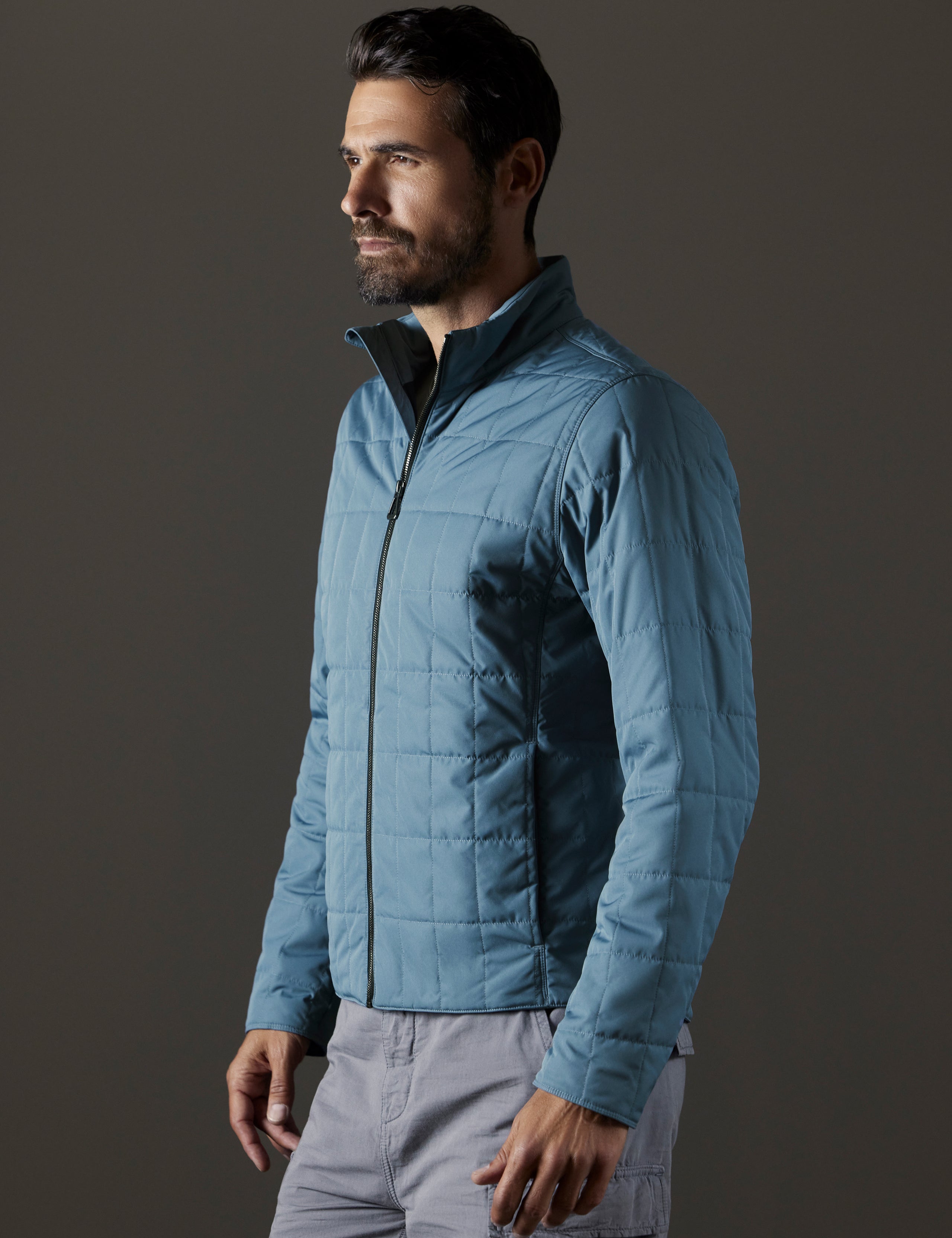 Front 3/4 body view of man wearing Alto Jacket in Portal Blue from AETHER Apparel.