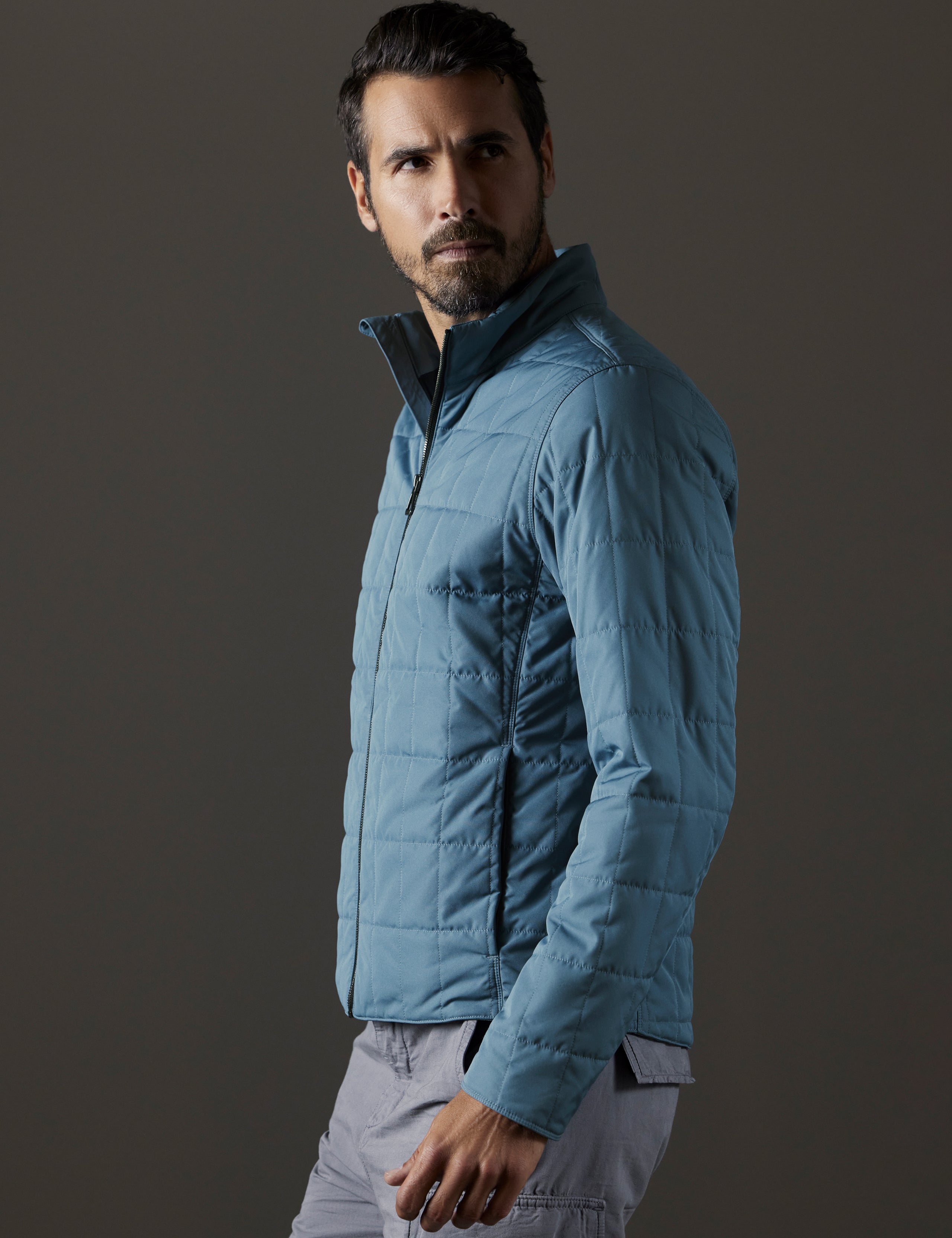Side profile body view of man wearing Alto Jacket in Portal Blue from AETHER Apparel.