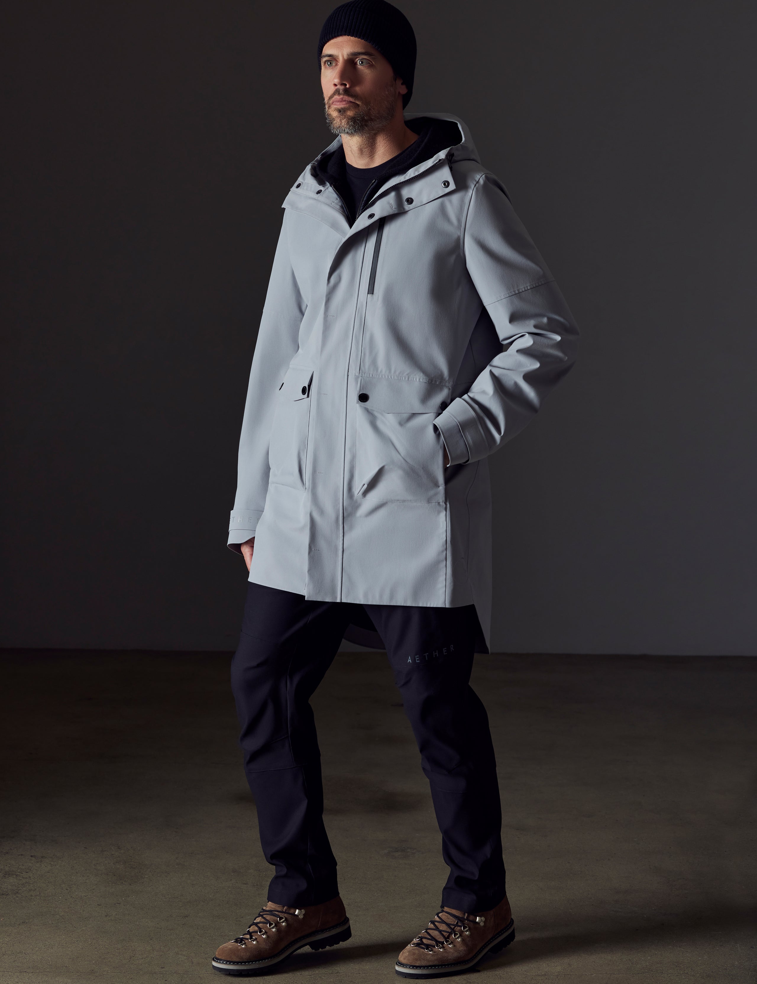 Front 3/4 full-body view of man wearing Anders Rain Jacket in Sky Grey from AETHER Apparel.