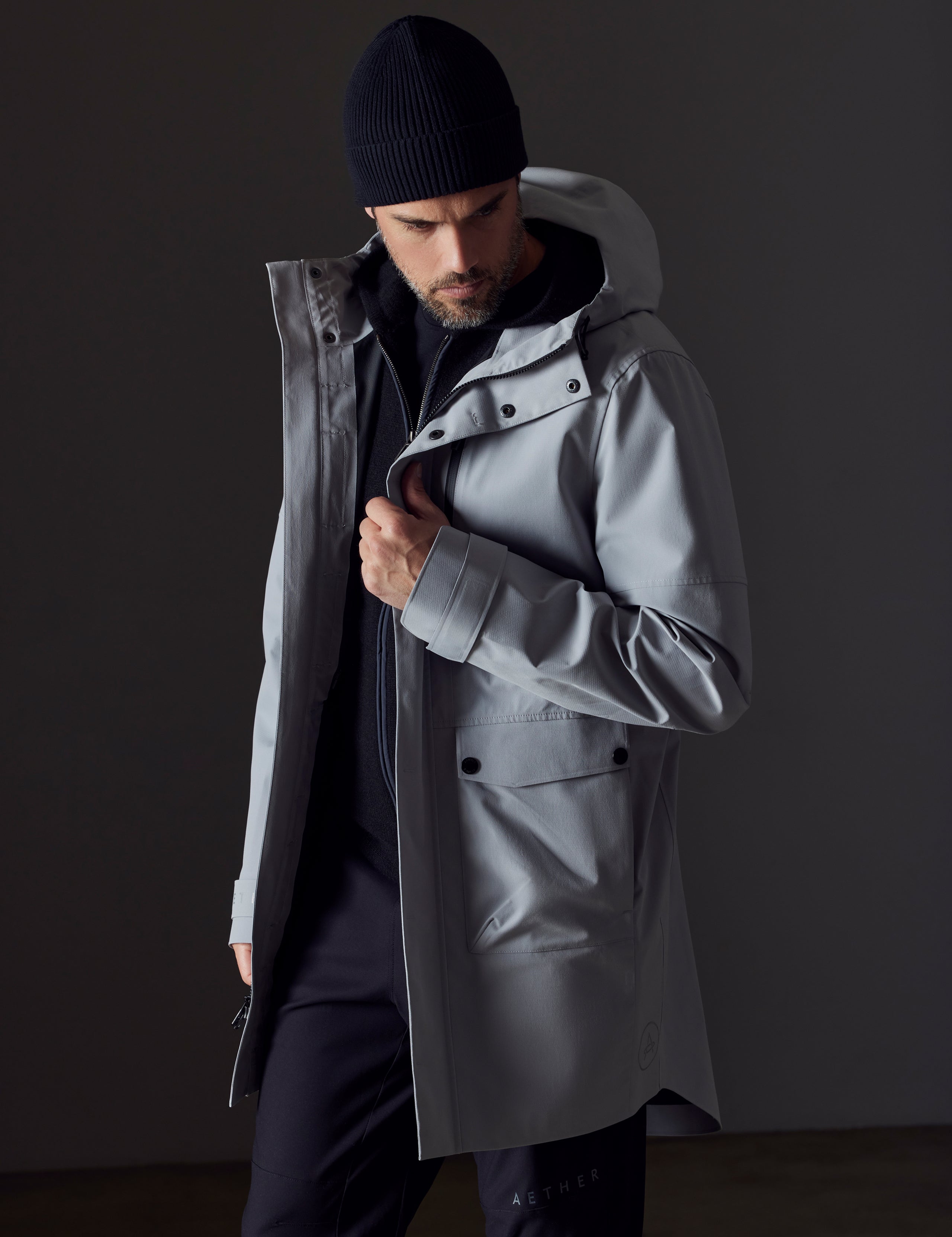 Front 3/4 body view of man wearing Anders Rain Jacket in Sky Grey from AETHER Apparel.
