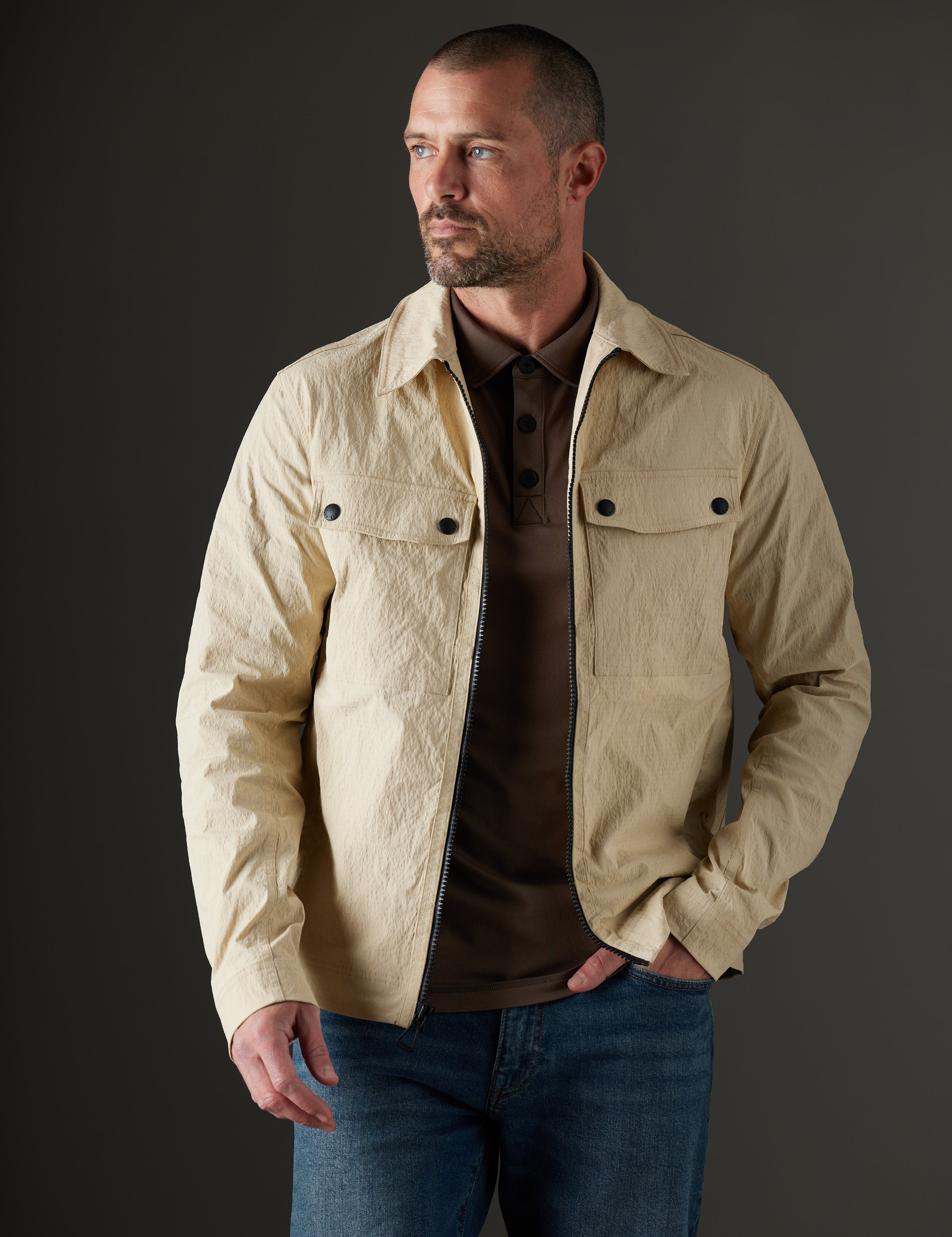 Front body view of man wearing unzipped Baxter Jacket in Desert Tan from AETHER Apparel.