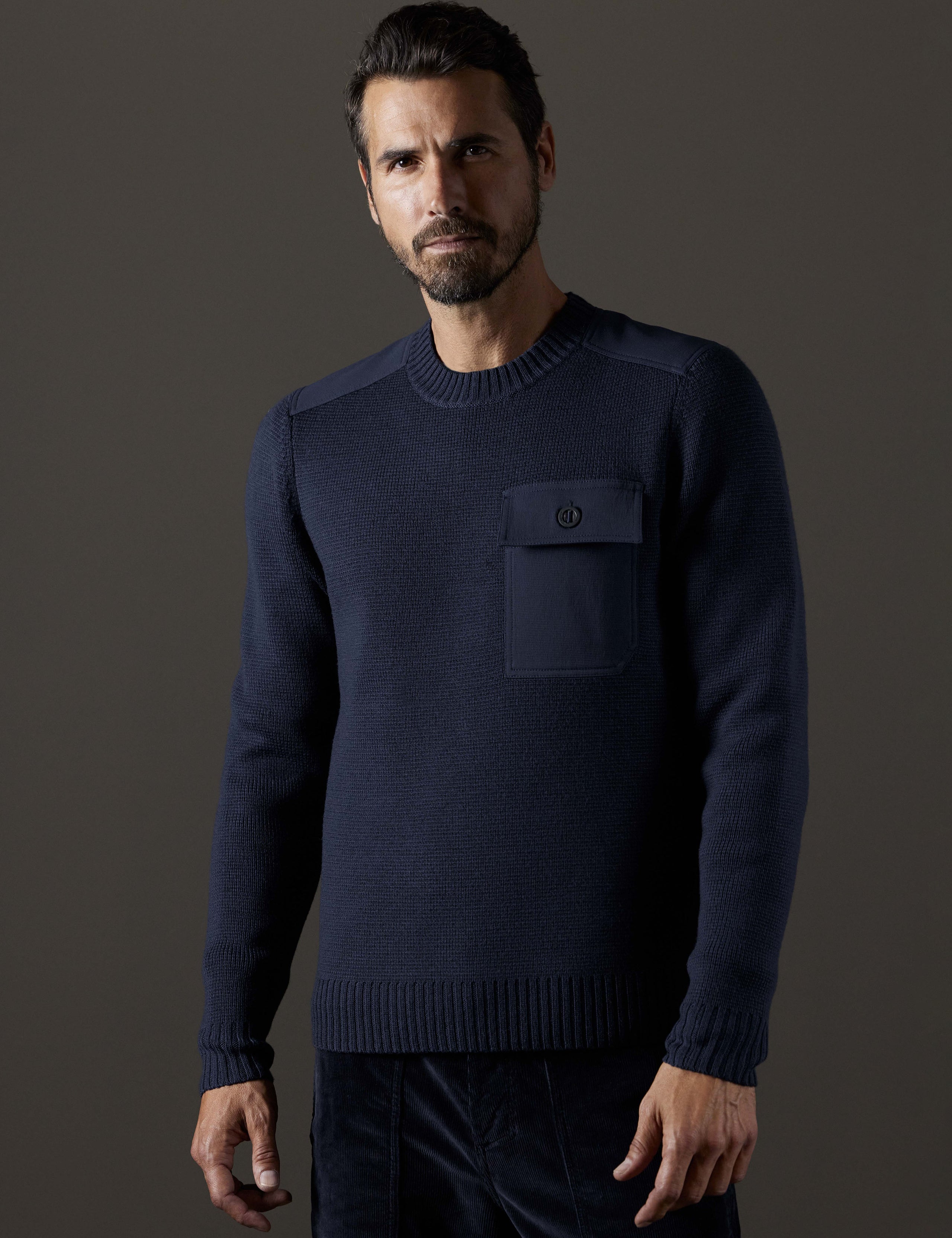 Front 3/4 body view of man wearing Benson Crewneck Sweater in Total Eclipse dark blue from AETHER Apparel.