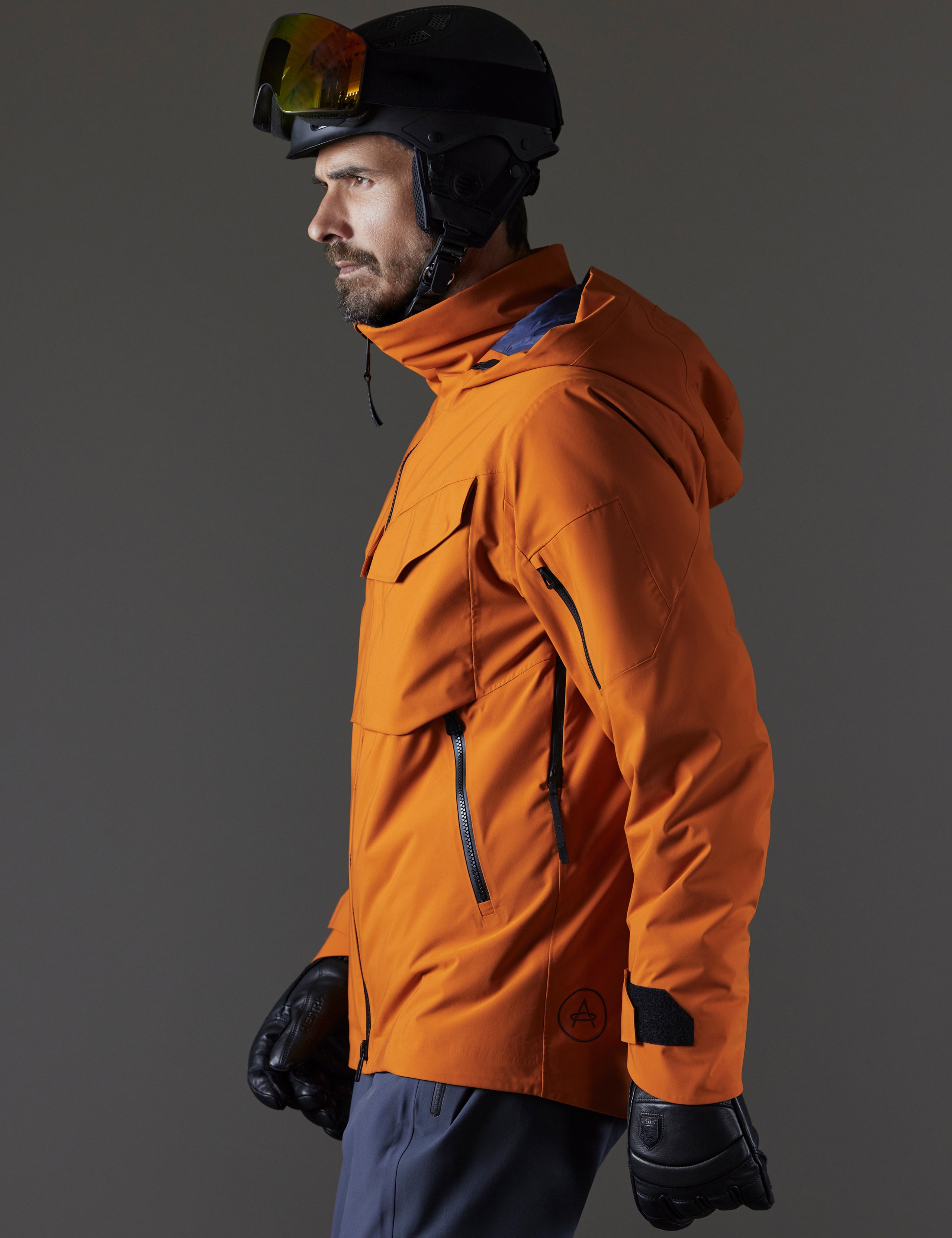 Side profile body view of man wearing Brighton Insulated Snow Jacket in Autumn Orange from AETHER Apparel.