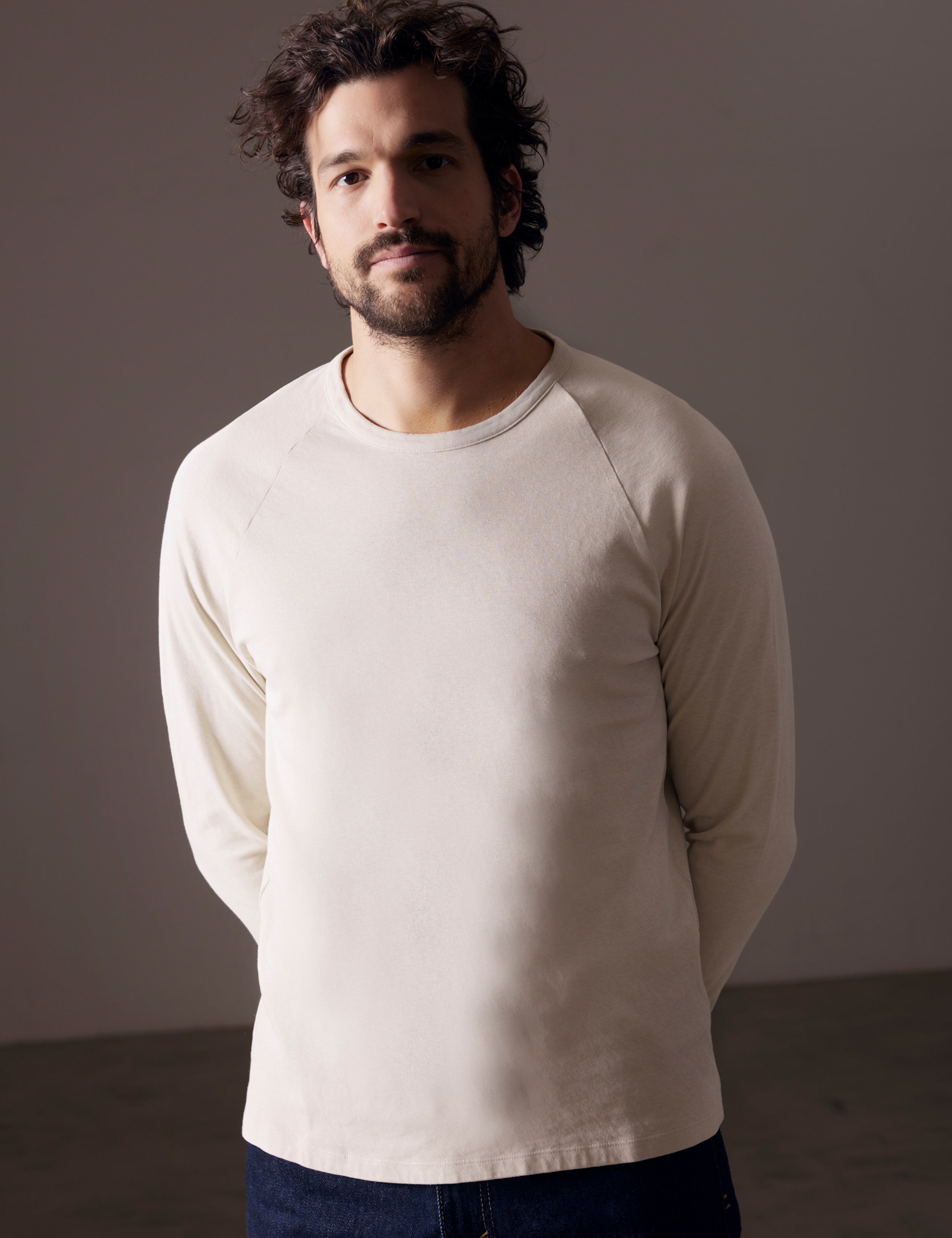 Front body view of man wearing Buckhorn Cotton Raglan Long-Sleeve Tee in Bone white from AETHER Apparel.