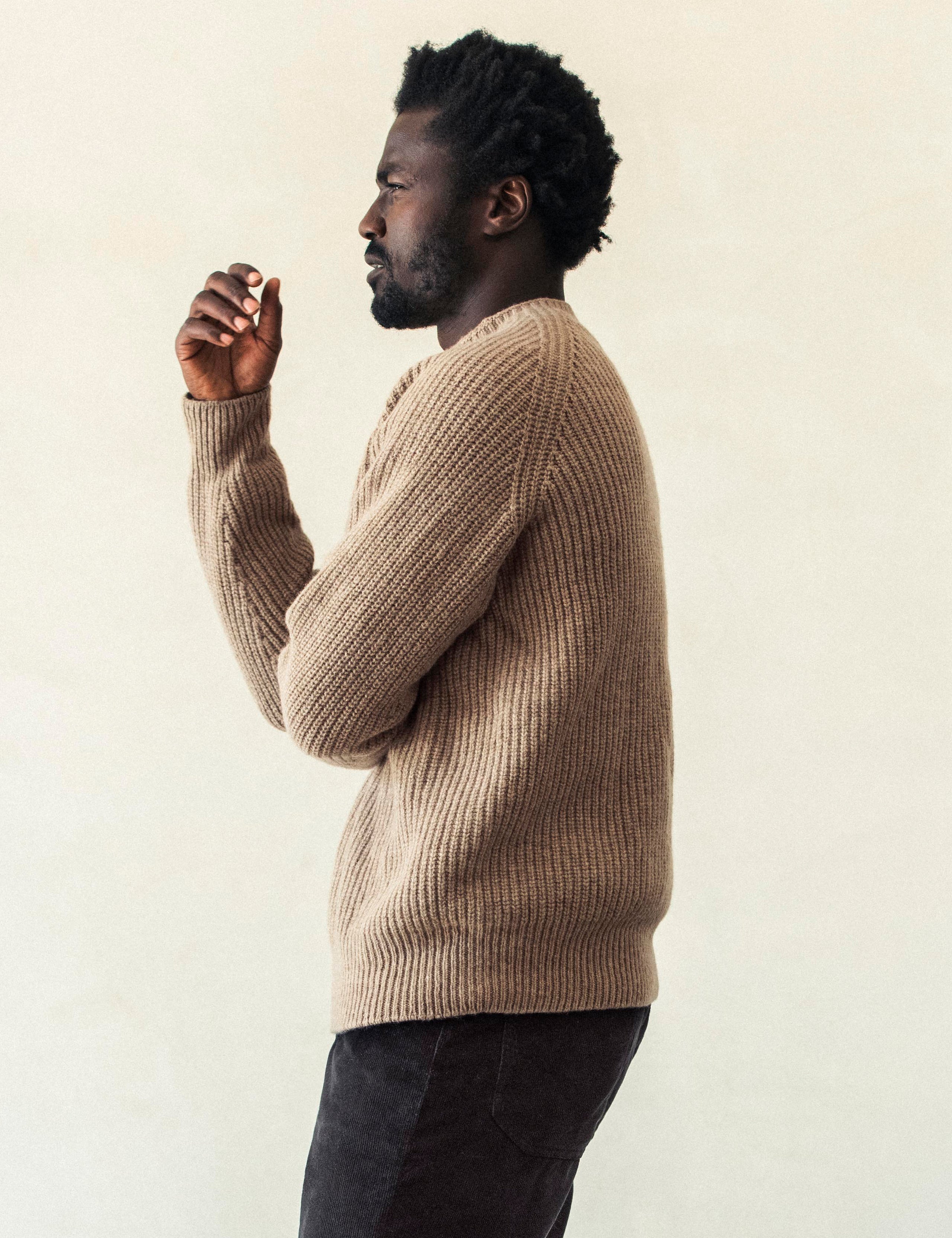 Side profile body view of man wearing Camden Crewneck Sweater In Chestnut Brown from AETHER Apparel