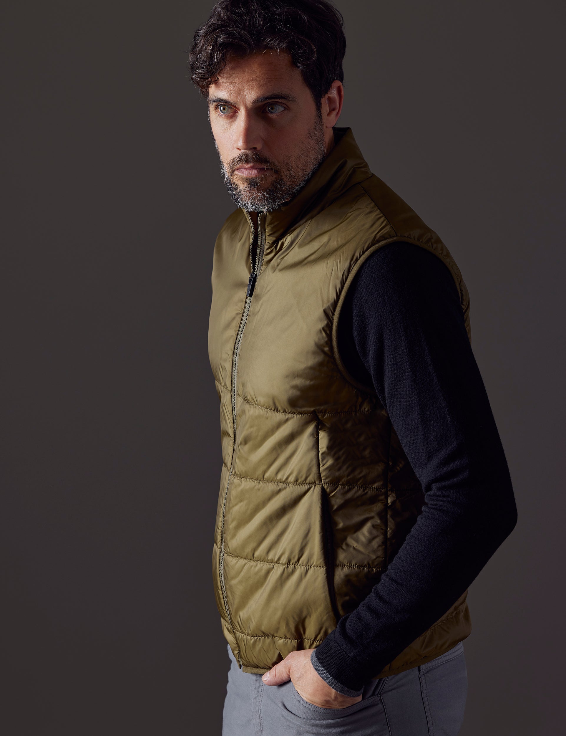 Side profile body view of man wearing Eco Insulated Vest in Command Green from AETHER Apparel.