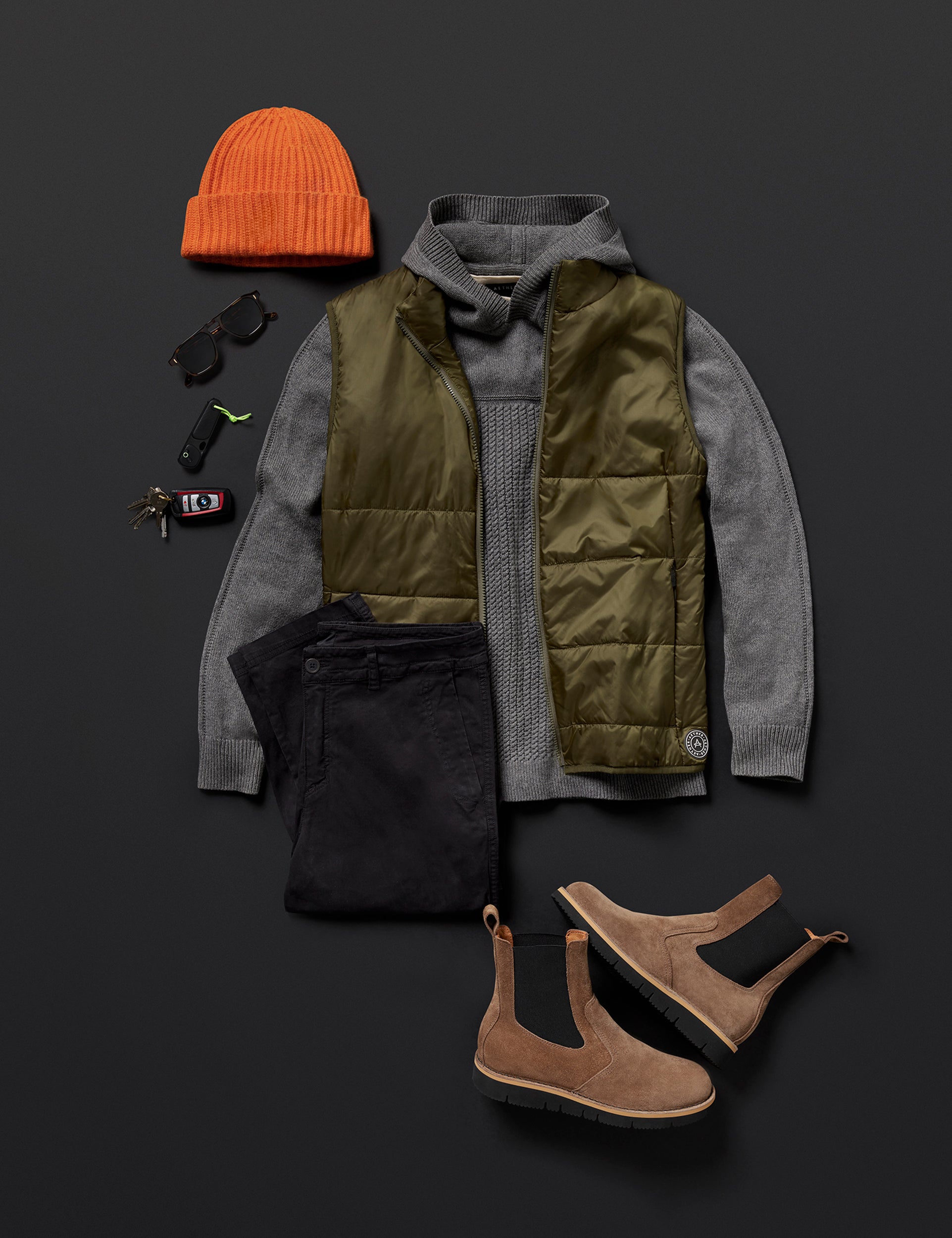 Flat lay image of curated men's outfit including Eco Insulated Vest in Command Green from AETHER Apparel.