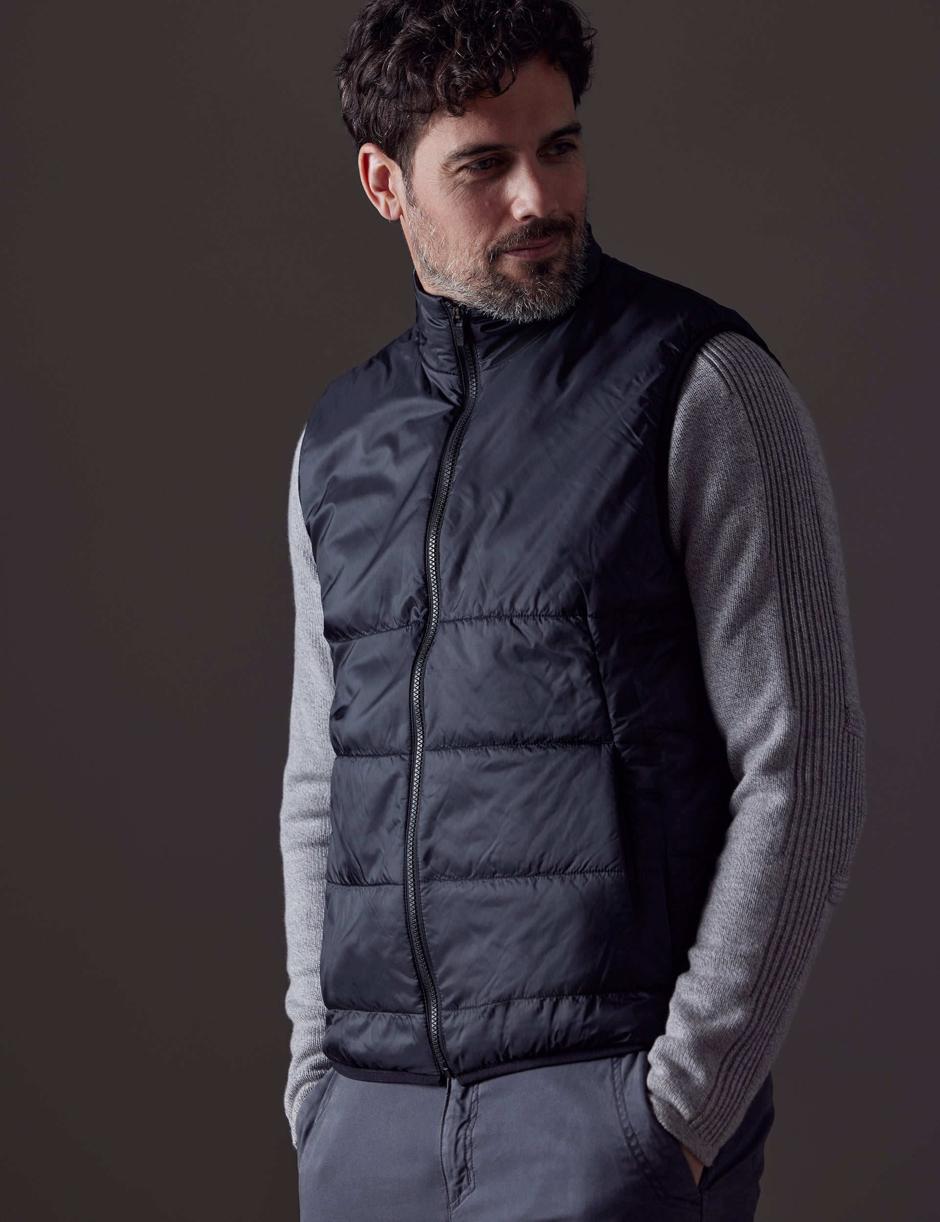 Front body view of man wearing Eco Insulated Vest in Onyx Black from AETHER Apparel.