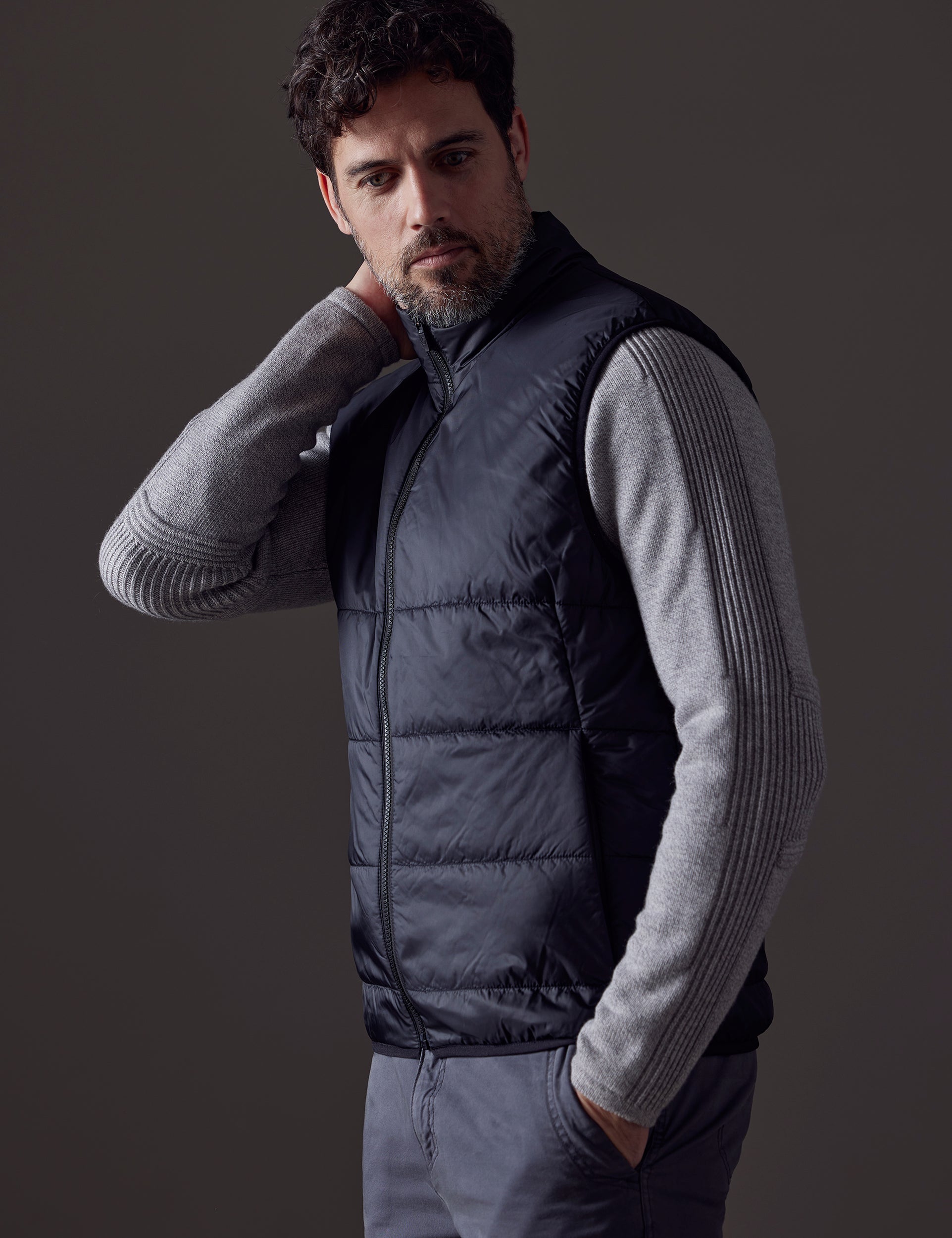 Side profile upper body view of man wearing Eco Insulated Vest in Onyx Black from AETHER Apparel.