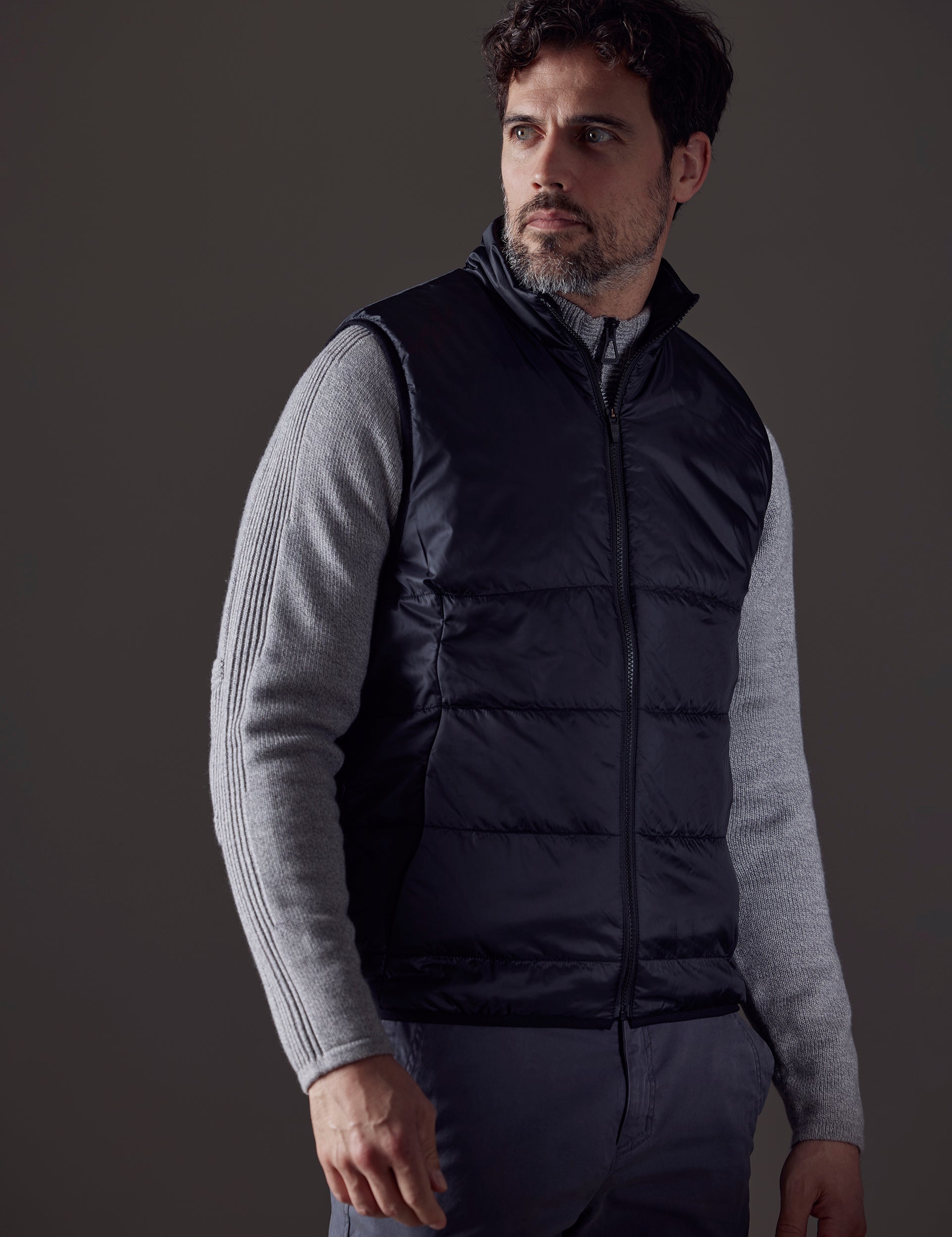 Front 3/4 body view of man wearing Eco Insulated Vest in Onyx Black from AETHER Apparel.
