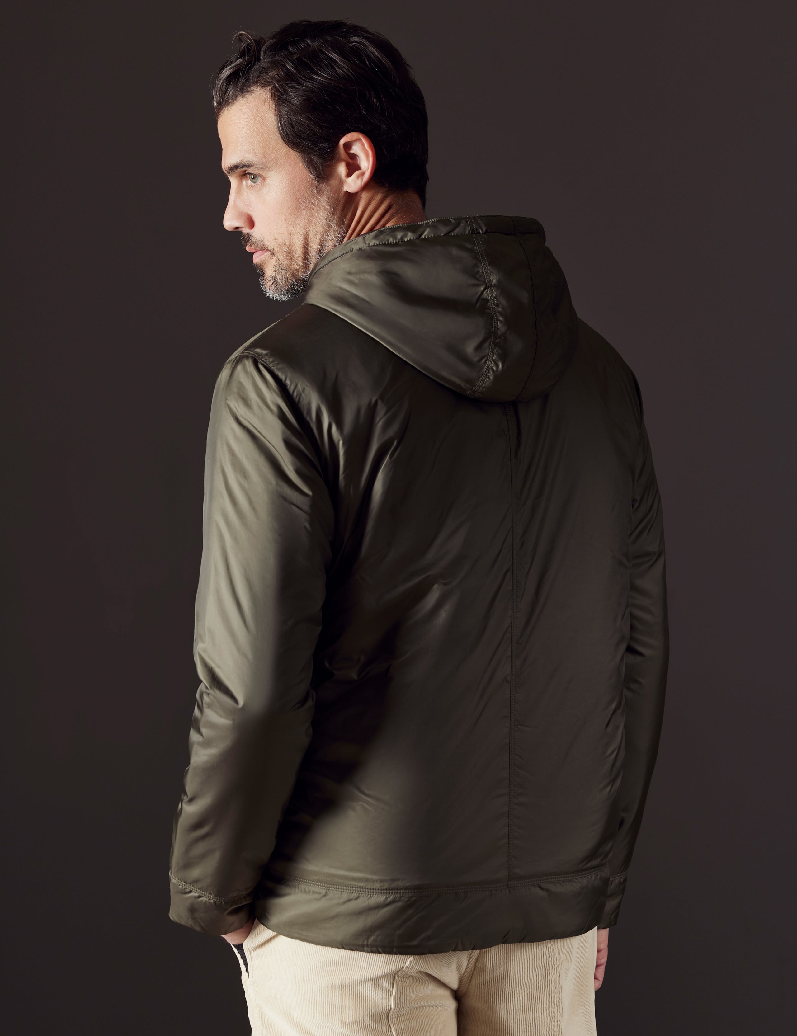 Rear 3/4 body view of man wearing Eco Space Hoodie in Hunter Green from AETHER Apparel.