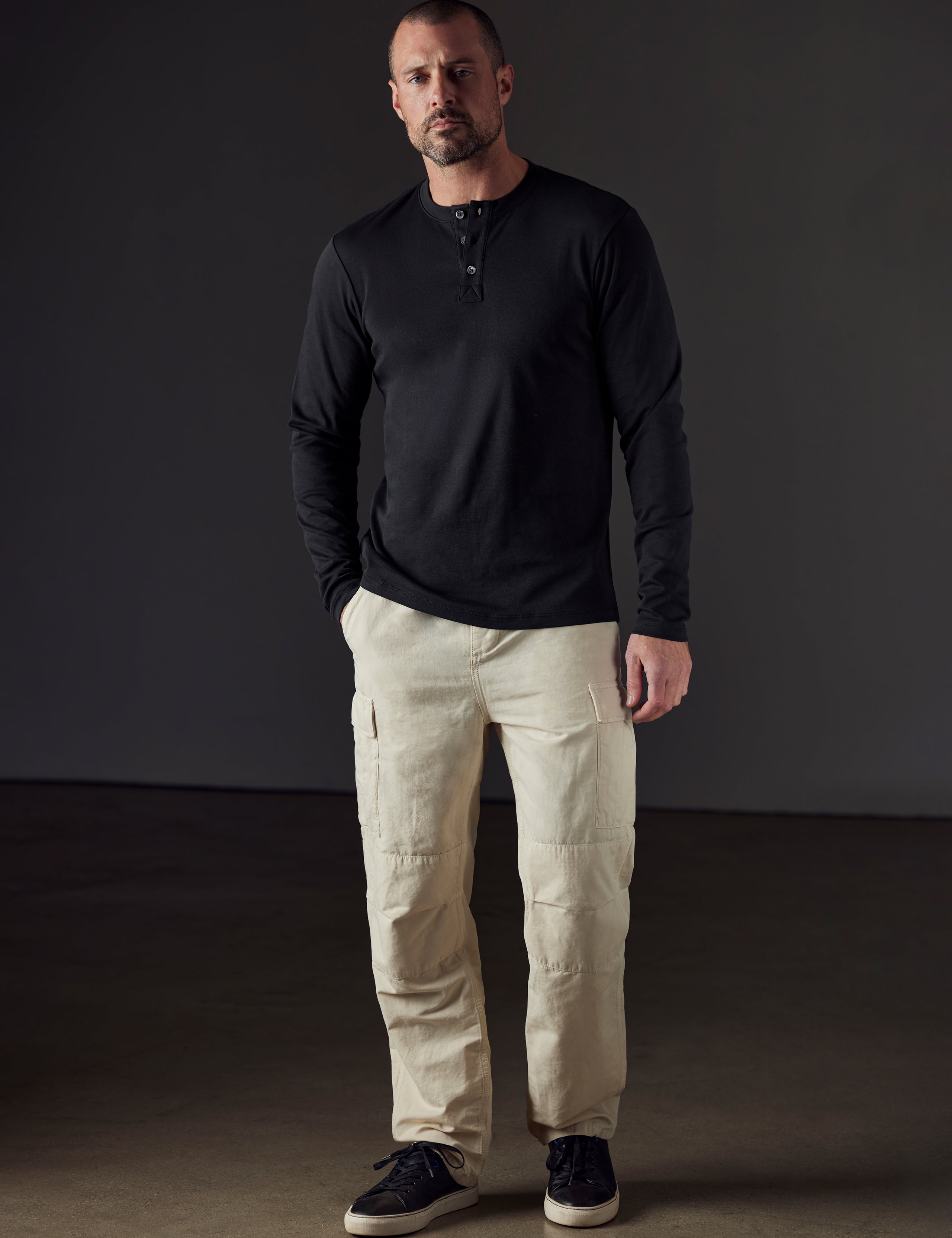 Front full-body view of man wearing Emery Pima Henley in Onyx Black from AETHER Apparel.