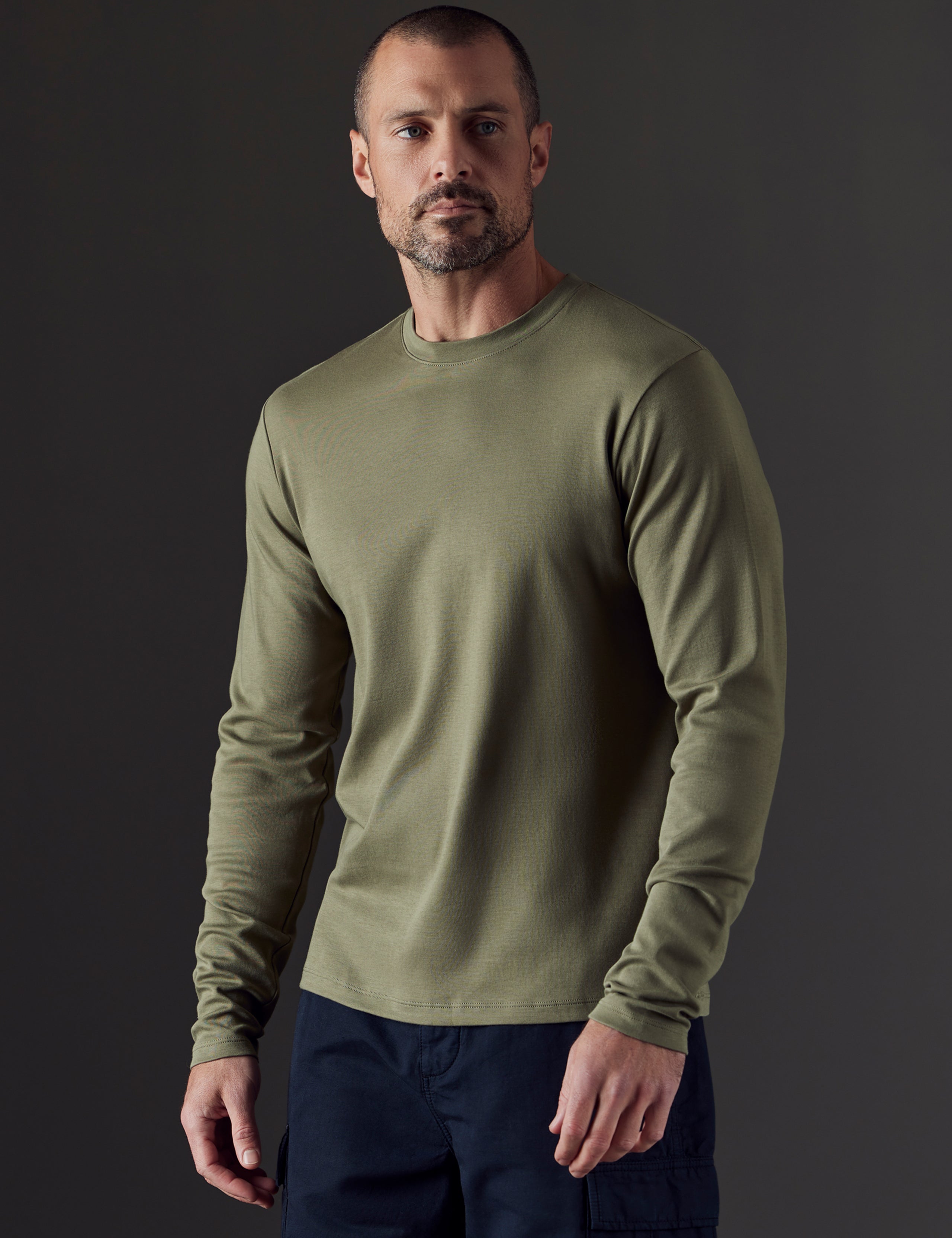 Front 3/4 body view of man wearing Emery Pima Long-Sleeve Tee in Fern Green from AETHER Apparel.