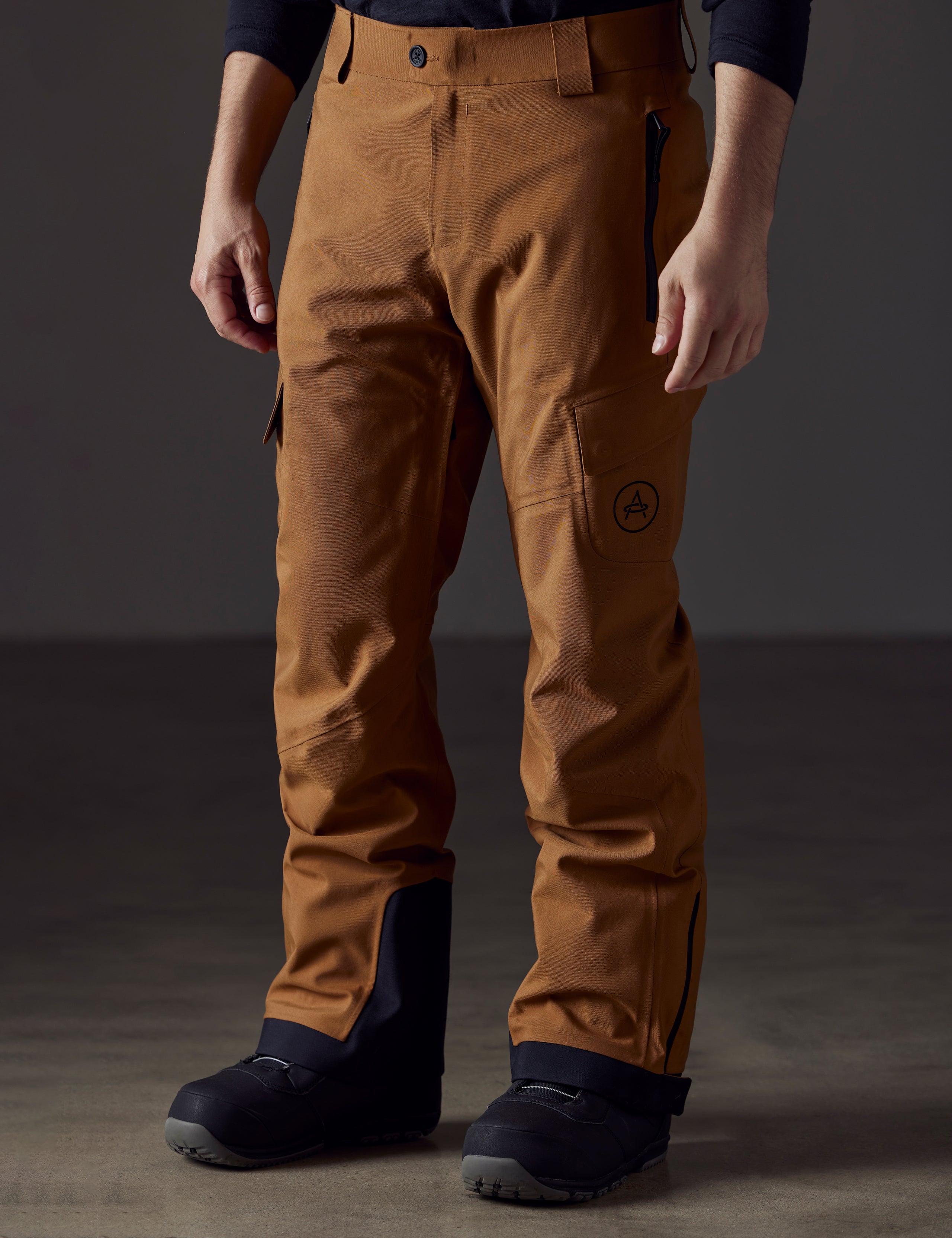 Front angled lower body view of man wearing Explorer Snow Pant in Rubber Brown from AETHER Apparel.