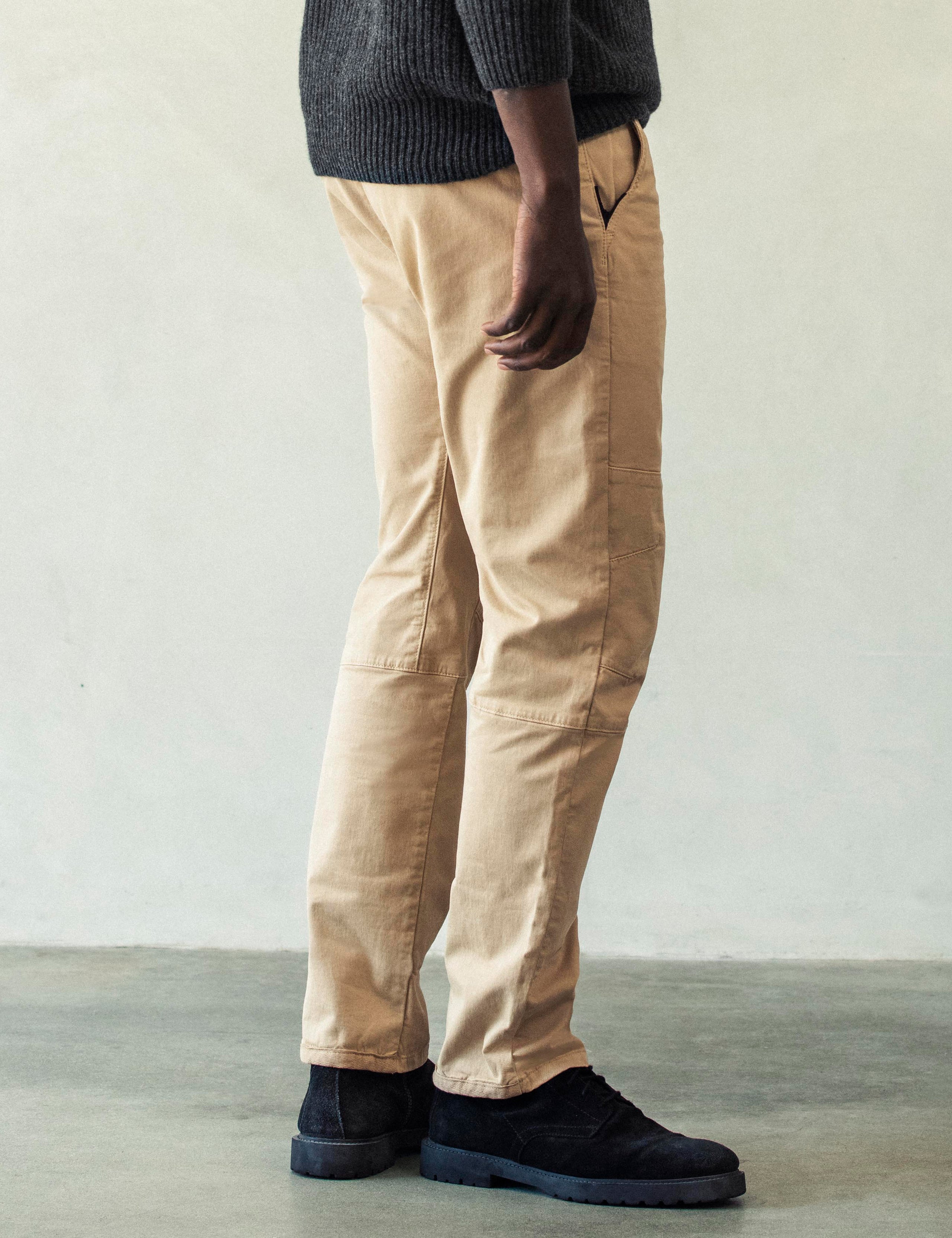 Right side profile lower body view of man wearing Gabriel Articulated Chino Stretch pant in Desert Tan from AETHER Apparel.