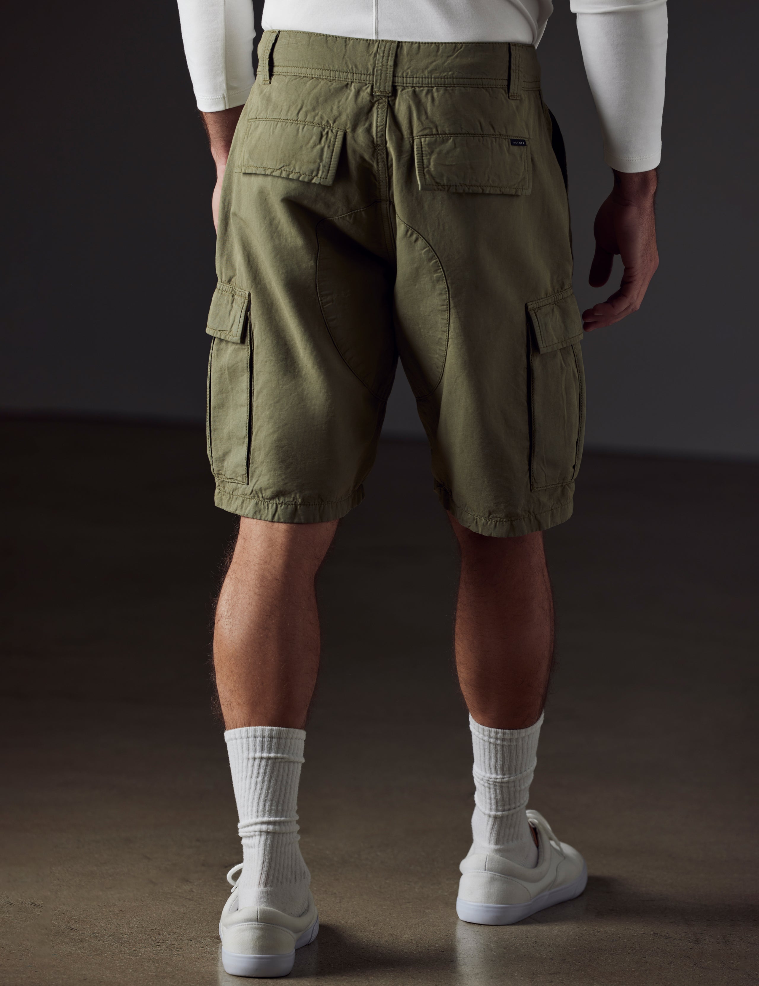 Rear 3/4 body view of man wearing Glade Fatigue Short in Fern Green from AETHER Apparel.