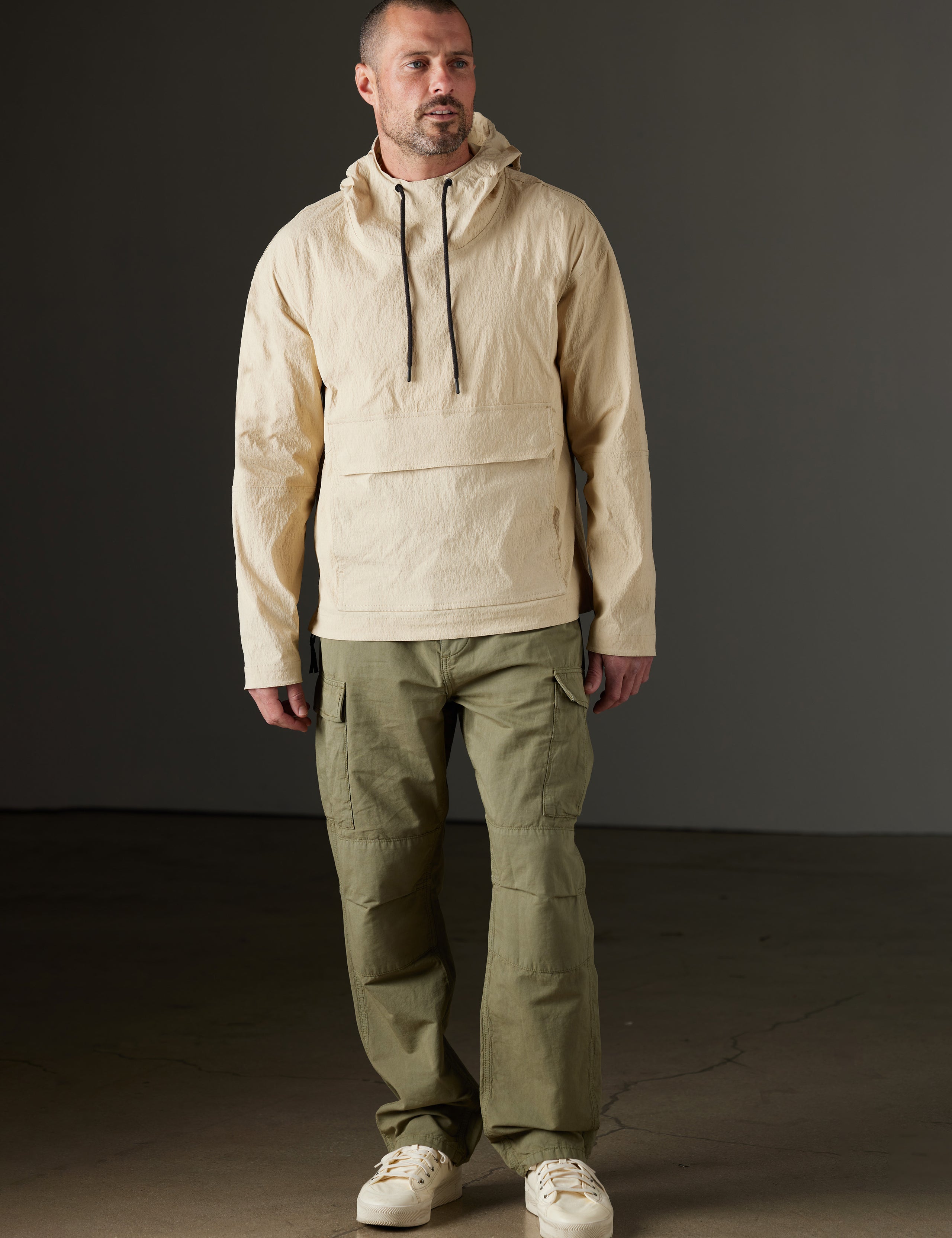 Front full-body view of man wearing Harrier Anorak in Desert Tan from AETHER Apparel.