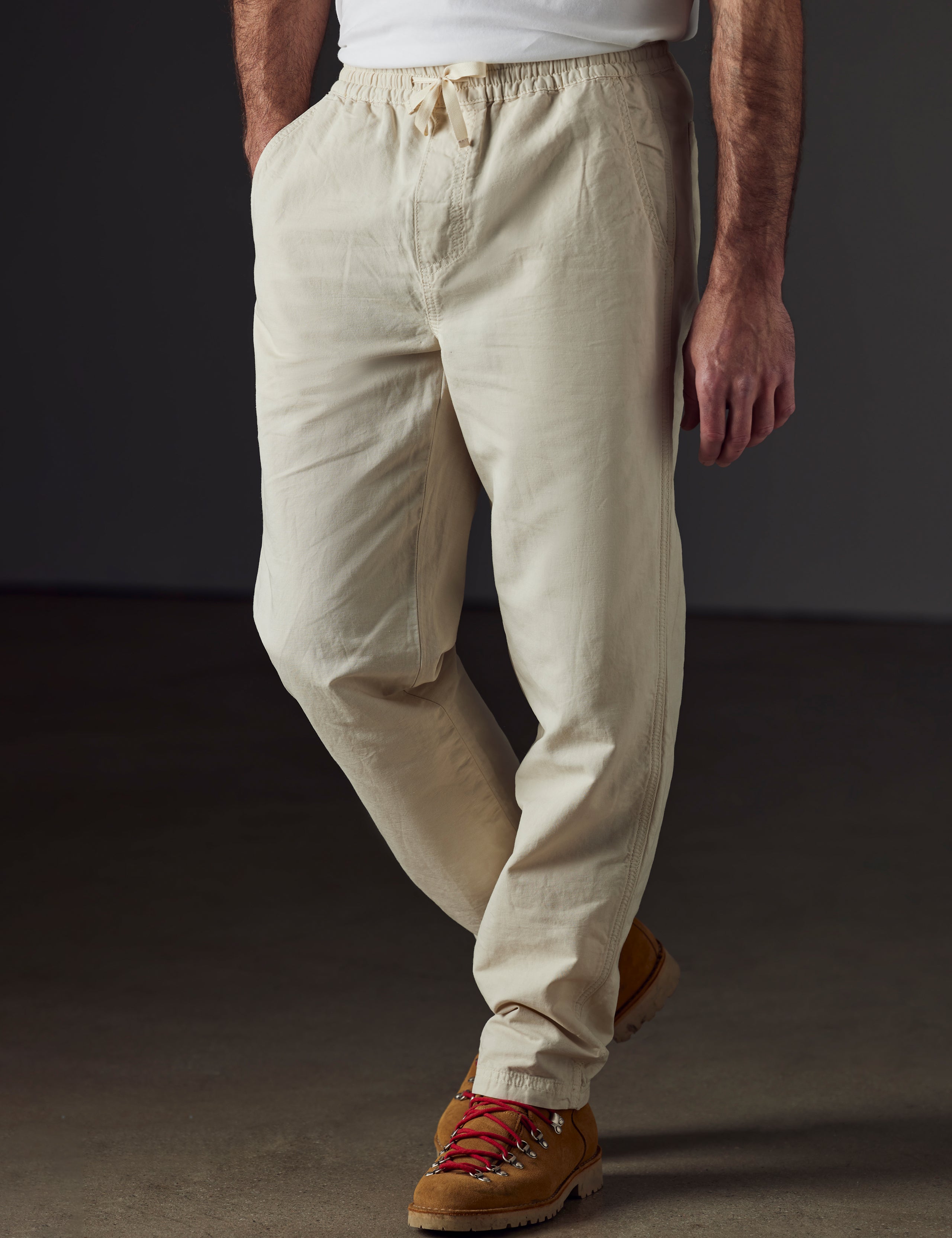 Front 3/4 lower body view of man wearing Highland Drawstring Pant in Bone White from AETHER Apparel.