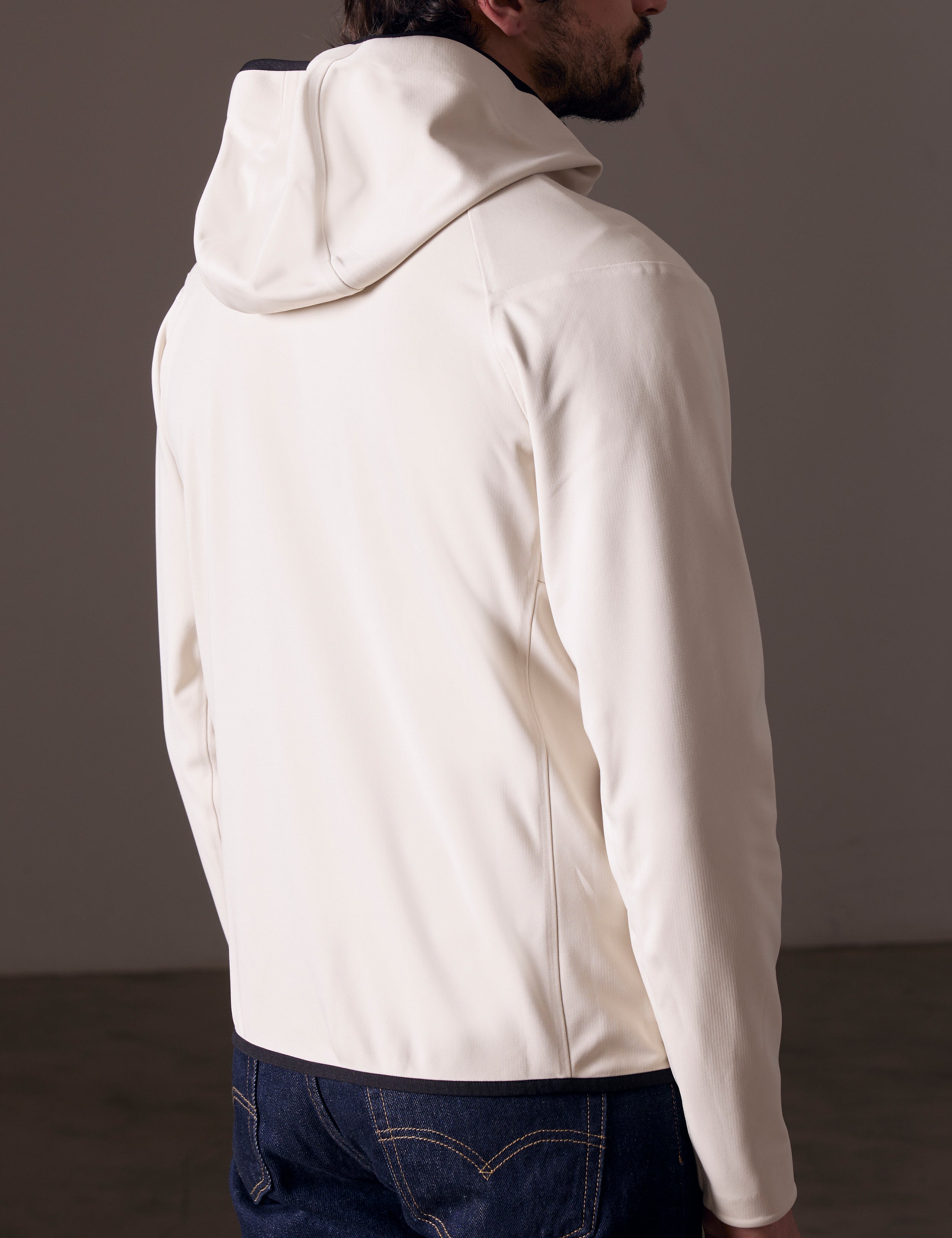 Rear 3/4 body view of man wearing Hooded Tech-Fleece Full-Zip in Bone white from AETHER Apparel.