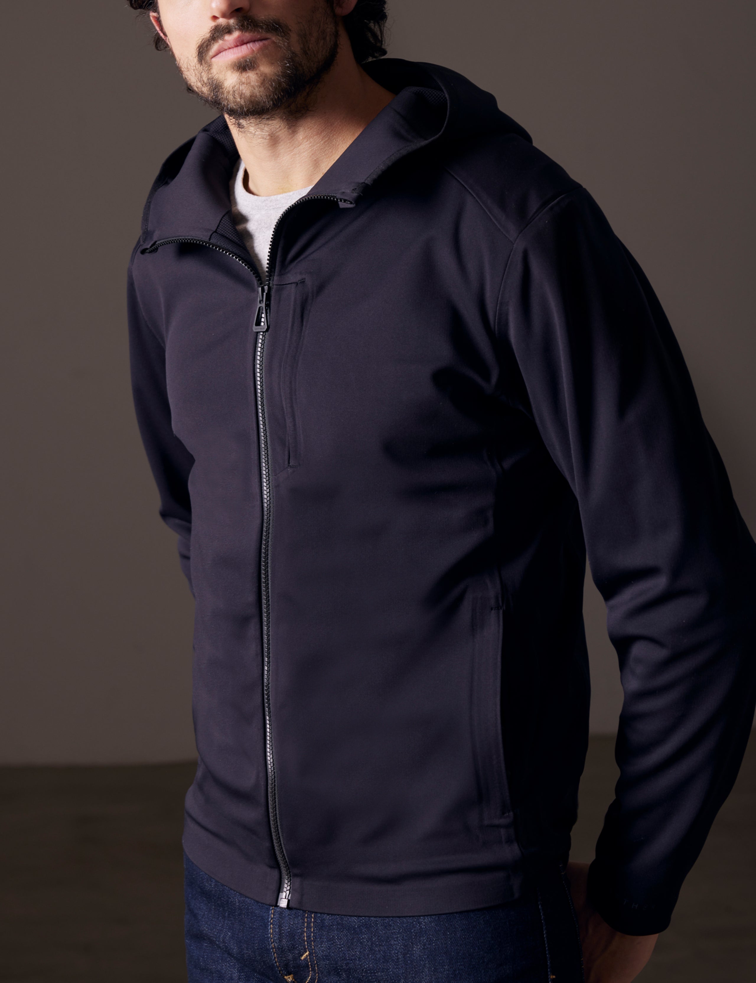 Front 3/4 body view of man wearing Hooded Tech-Fleece Full-Zip in Onyx Black from AETHER Apparel.