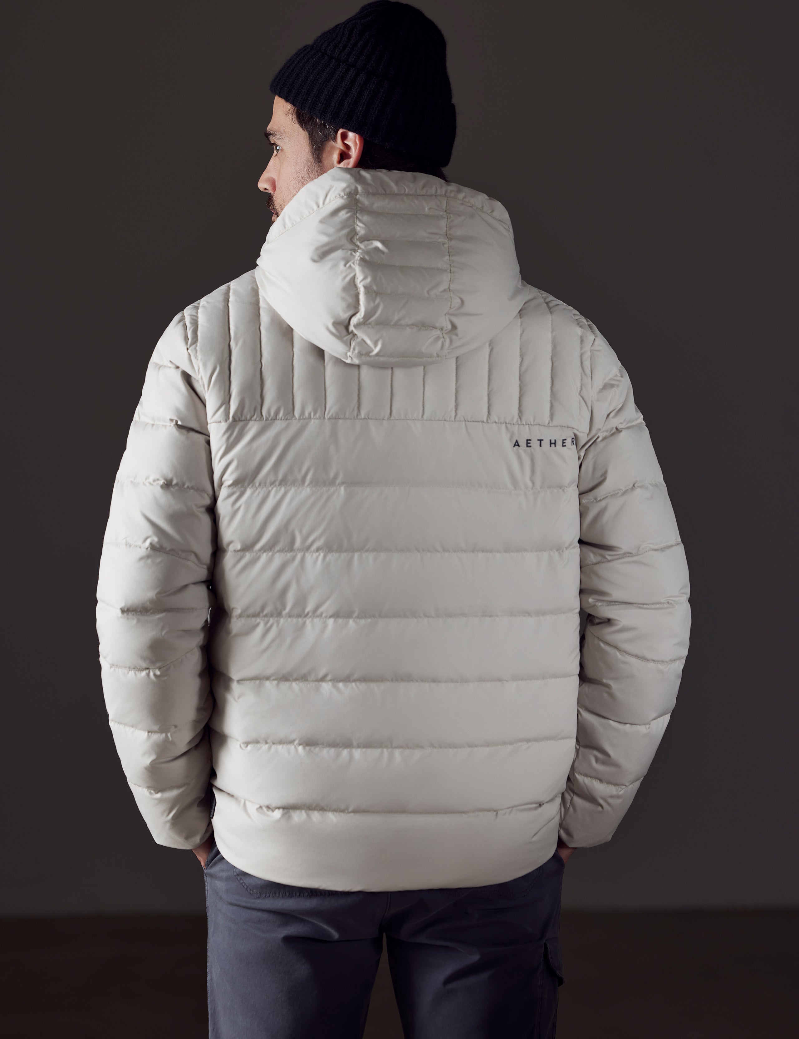 Rear body view of man wearing Hudson Down Jacket in Bone White from AETHER Apparel.