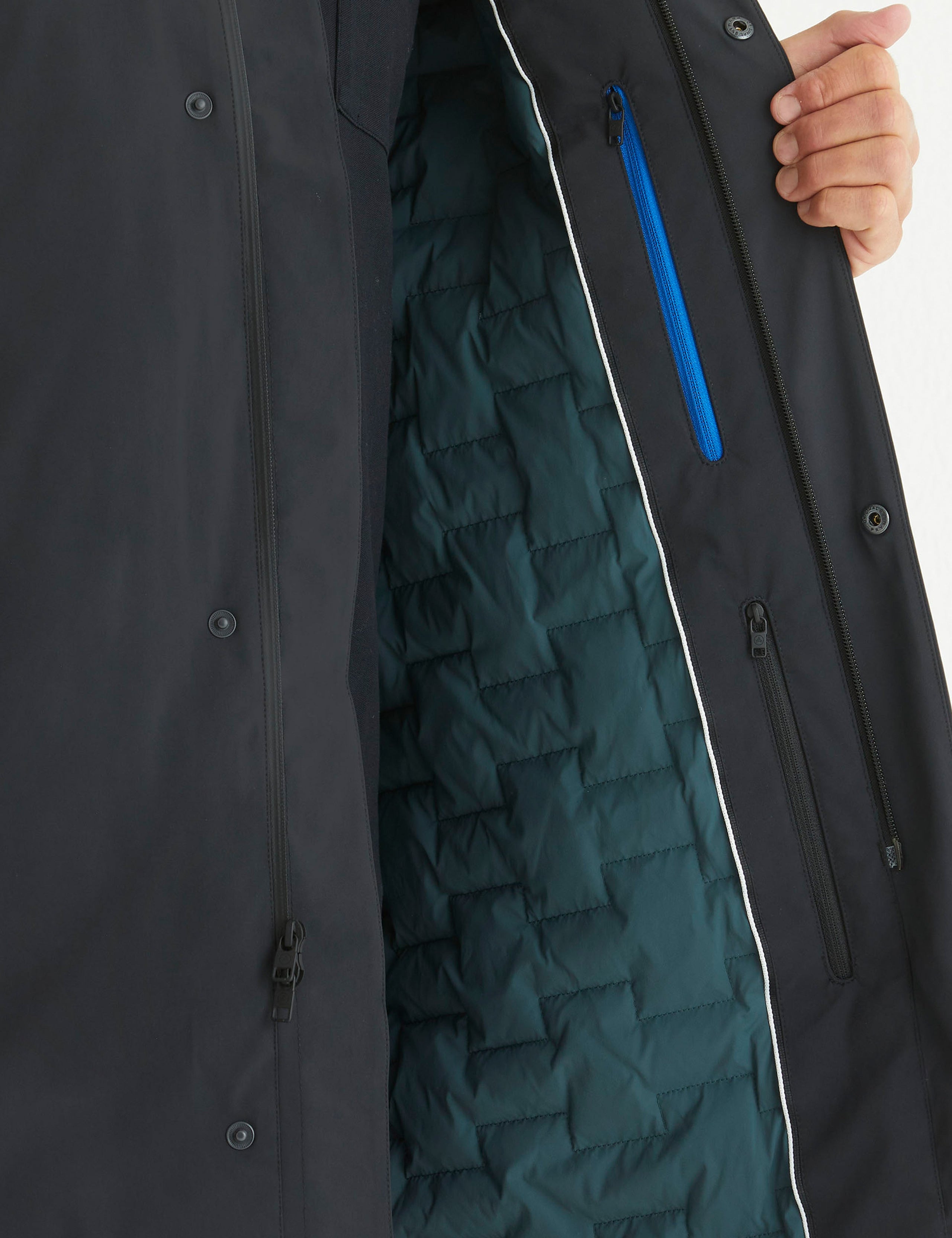 Detailed view at quilted lining and zippered pockets of Isaac Jacket in Onyx Black from AETHER Apparel.
