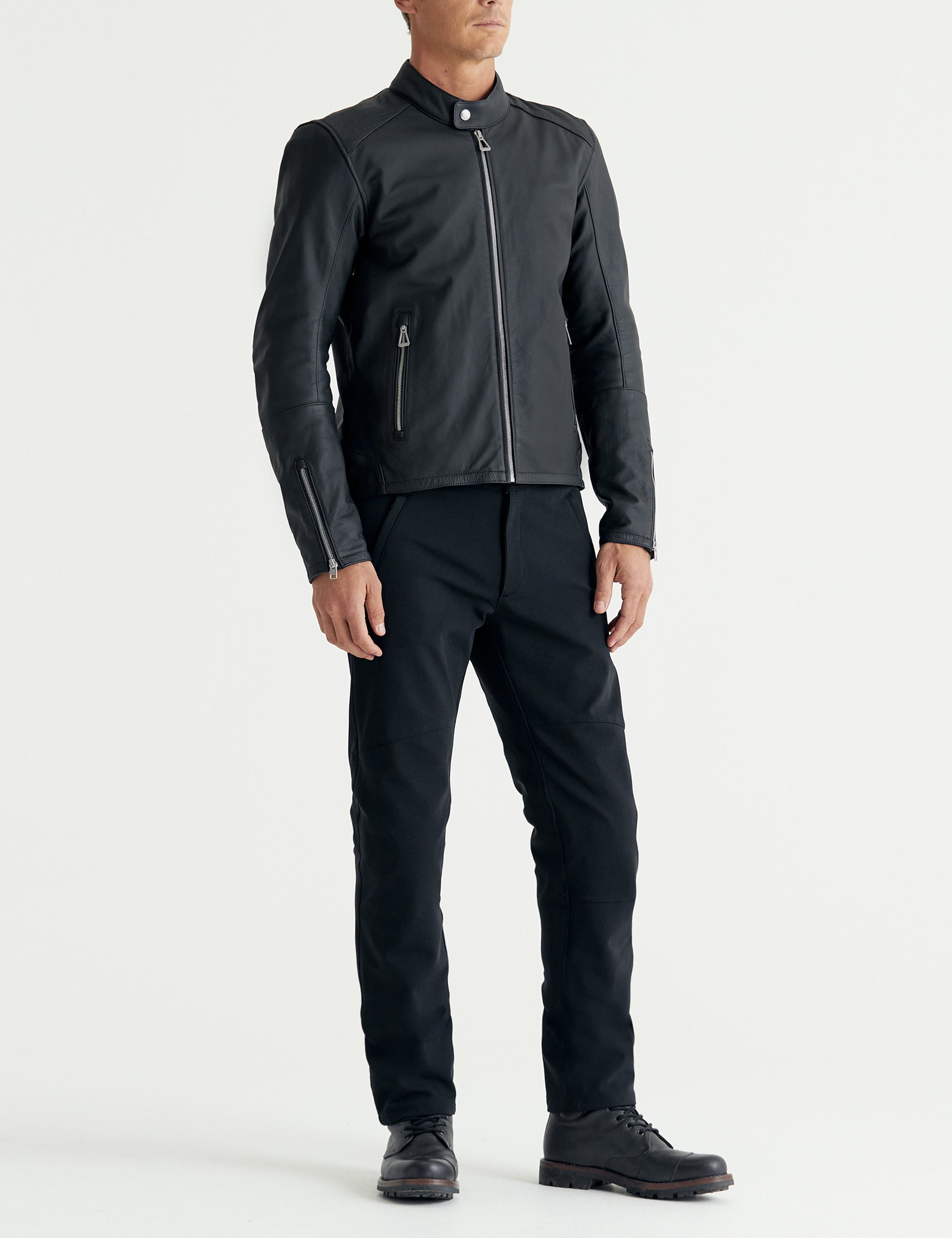 Front 3/4 full-body view of man wearing Laslo Motorcycle Jacket in Onyx Black from AETHER Apparel.