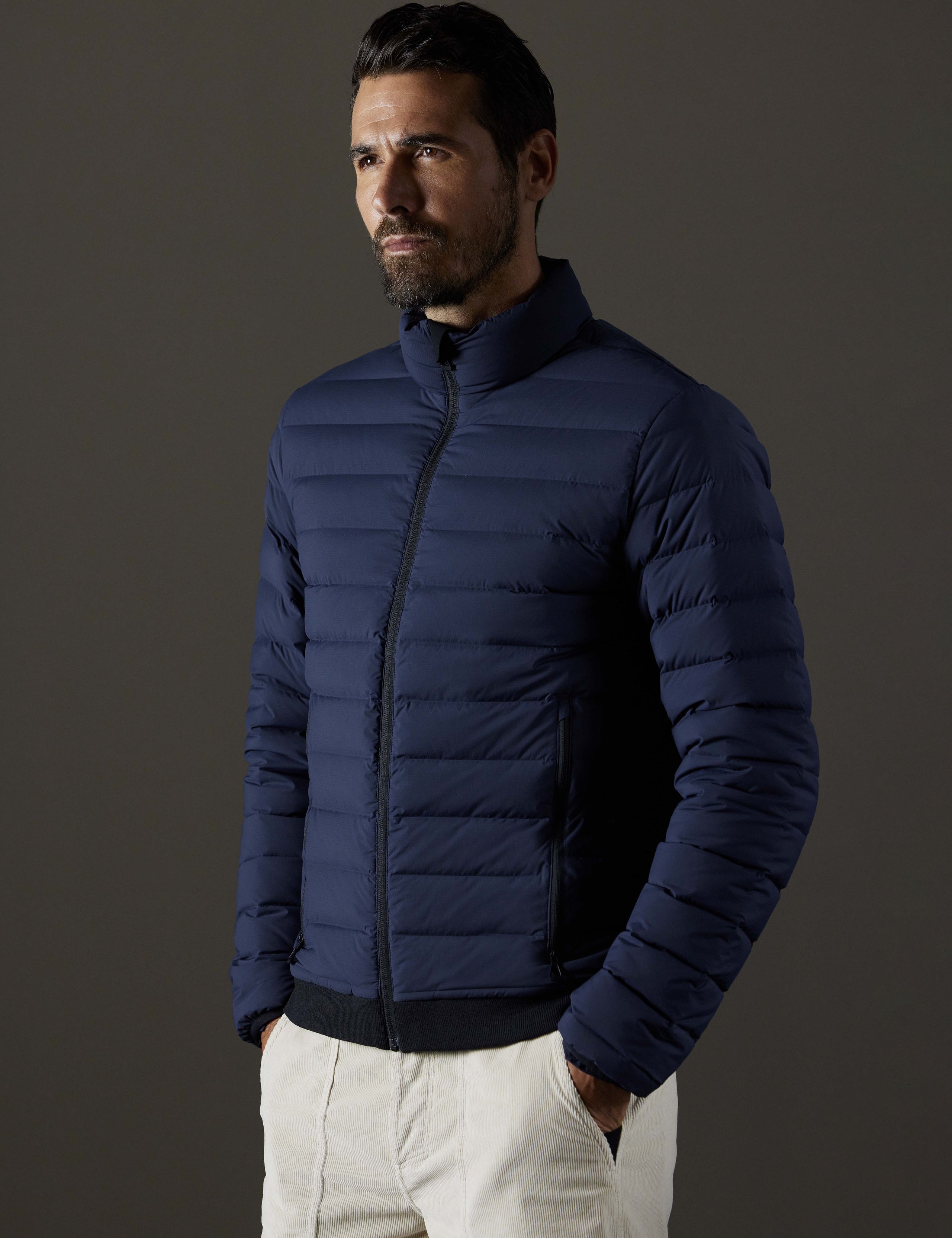 Front 3/4 body view of man wearing Launch Full-Zip Jacket NH in Total Eclipse dark blue from AETHER Apparel.