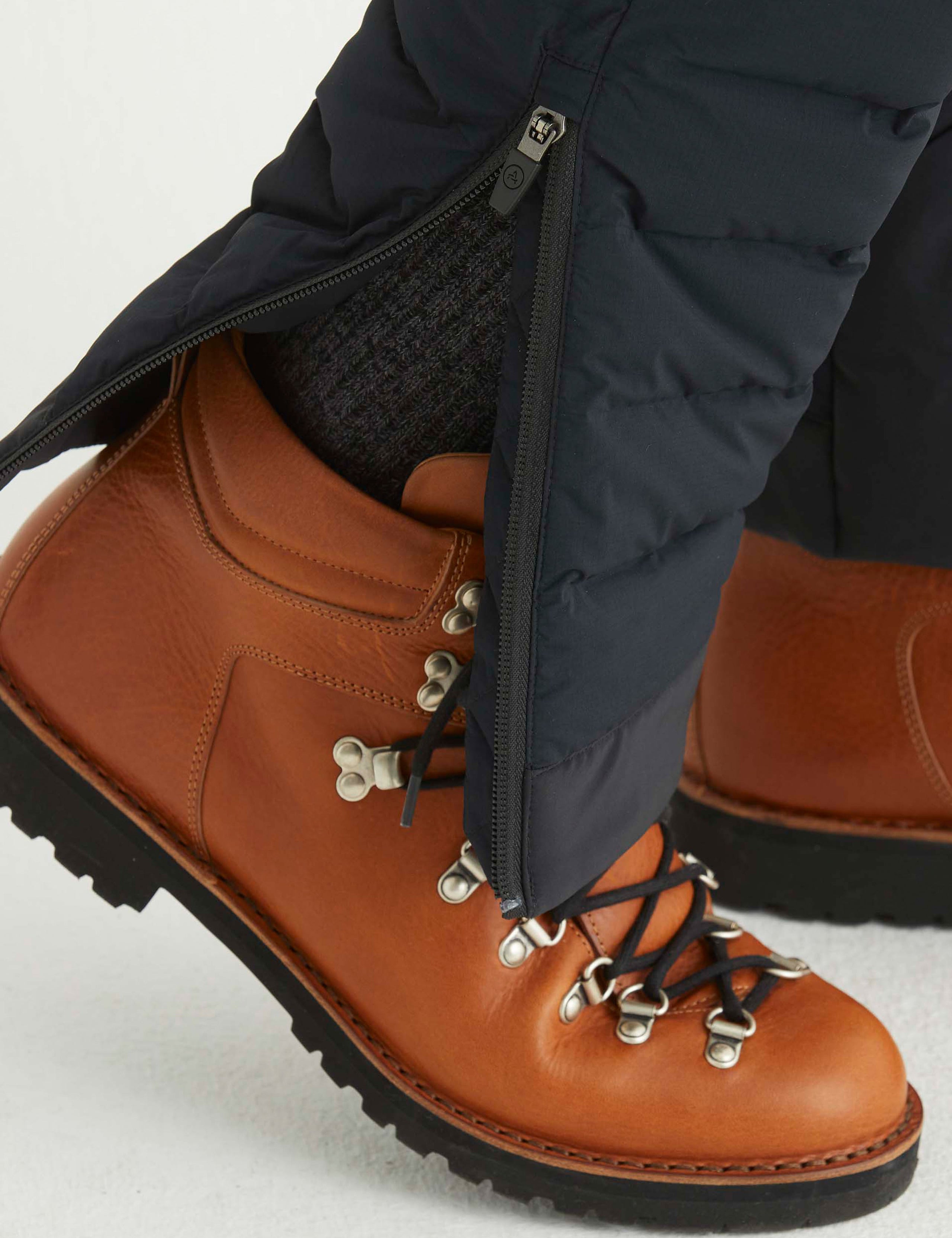 Closeup detailed view of zippered leg cuff opening on Launch Pant in Onyx Black from AETHER Apparel. 